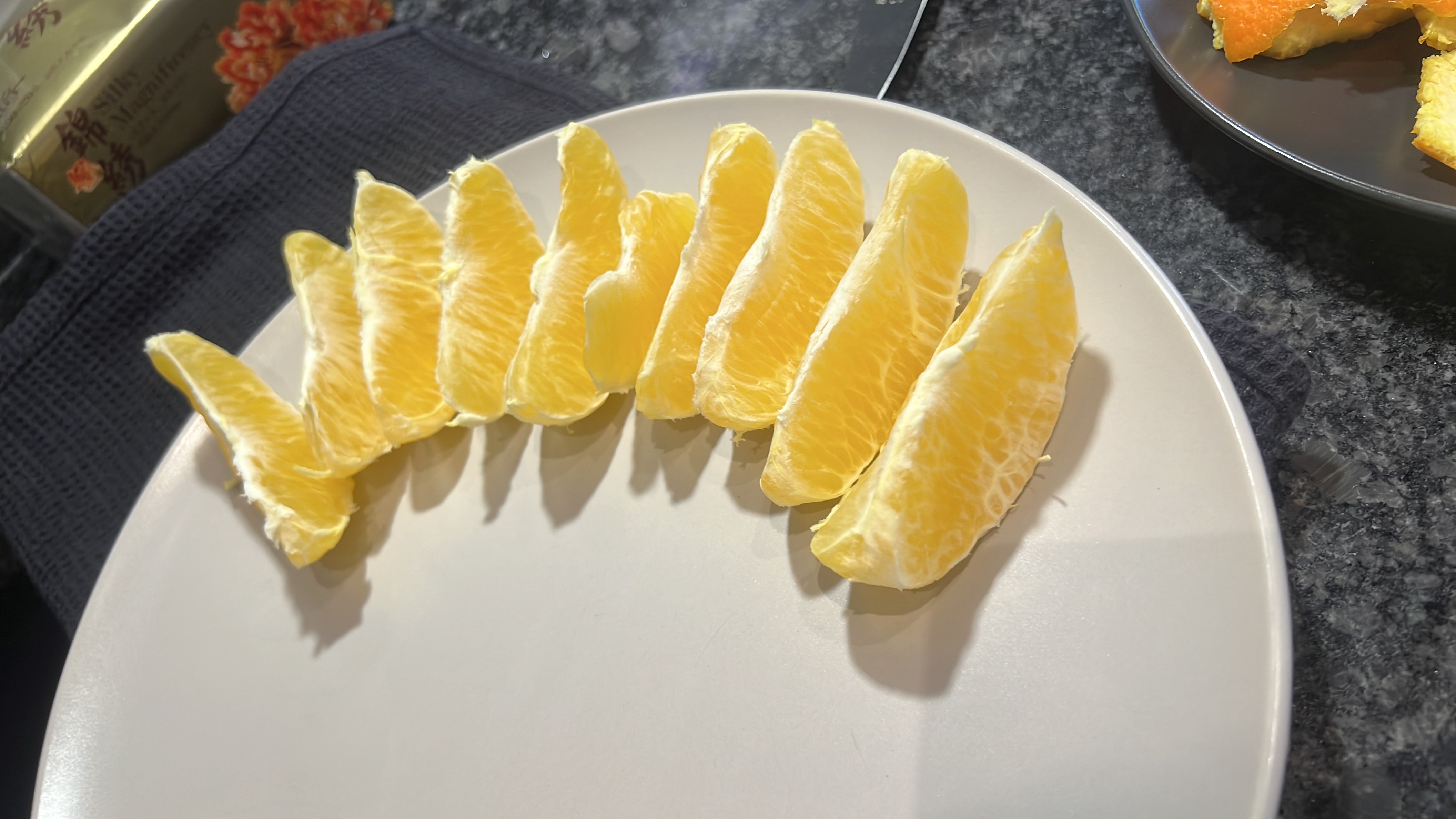 The image shows peeled orange slices arranged on a plate. Oranges are a low-calorie fruit rich in vitamin C, fiber, and natural sugars, making them a healthy snack option.