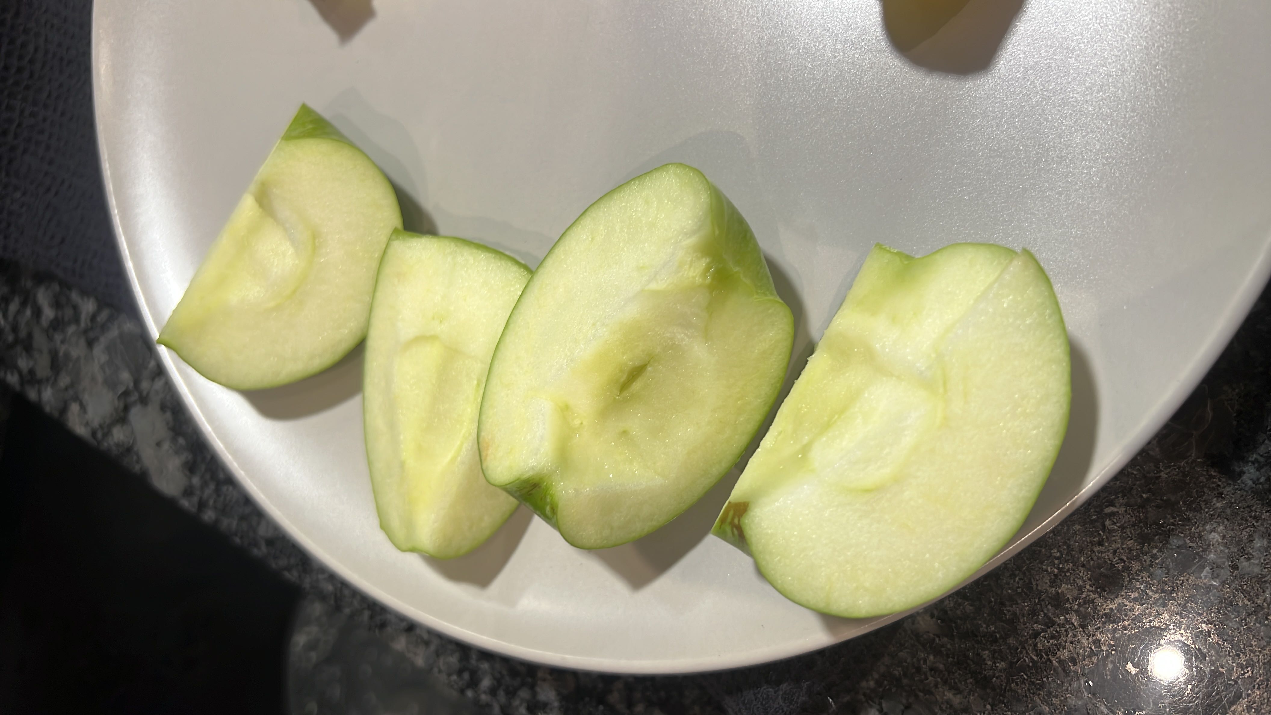 This image shows sliced green apples on a plate, which are a nutritious fruit rich in fiber and vitamins with a low calorie count.