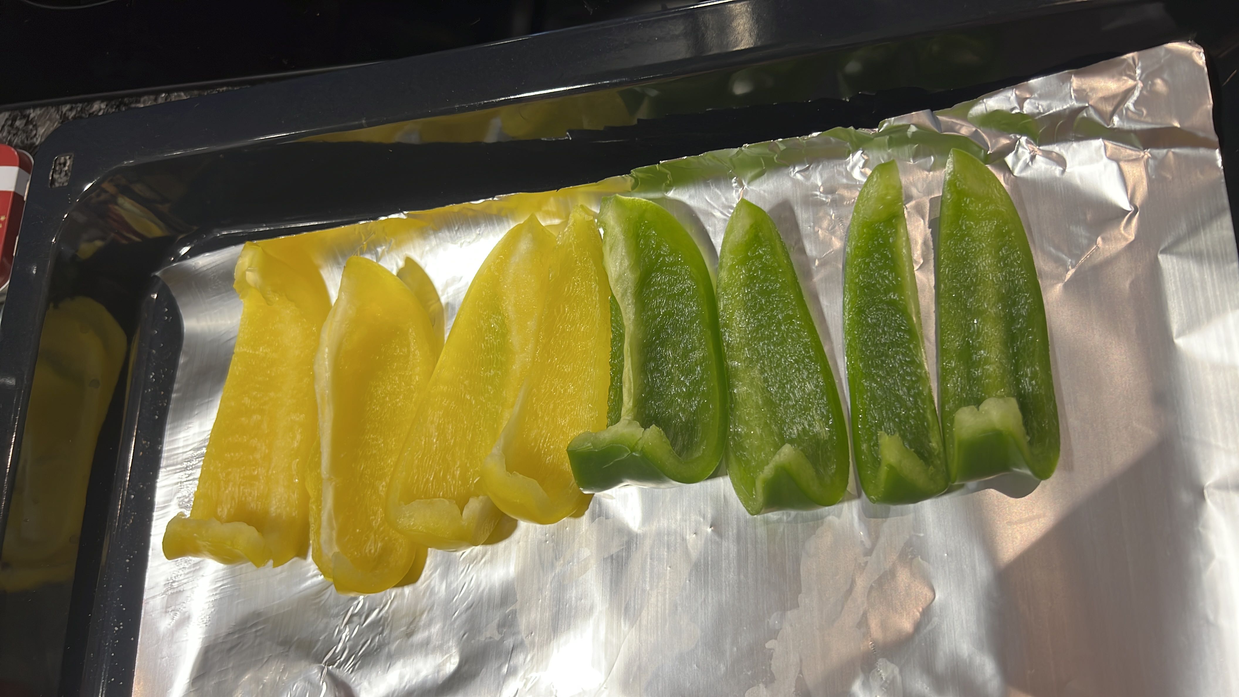 Sliced yellow and green bell peppers placed on a baking tray, providing a low-calorie, nutrient-rich option high in vitamins and fiber.