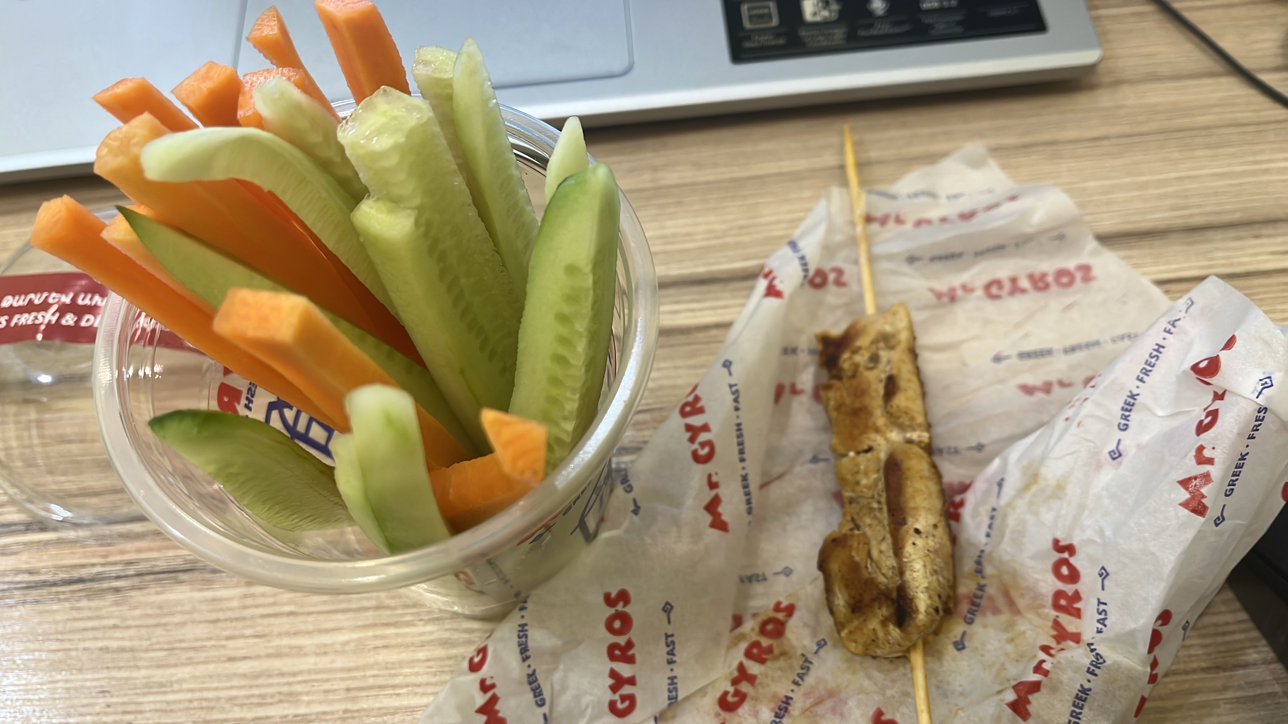 A healthy meal consisting of a grilled chicken skewer with fresh carrot and cucumber sticks, providing a balanced mix of protein, fiber, and essential nutrients.