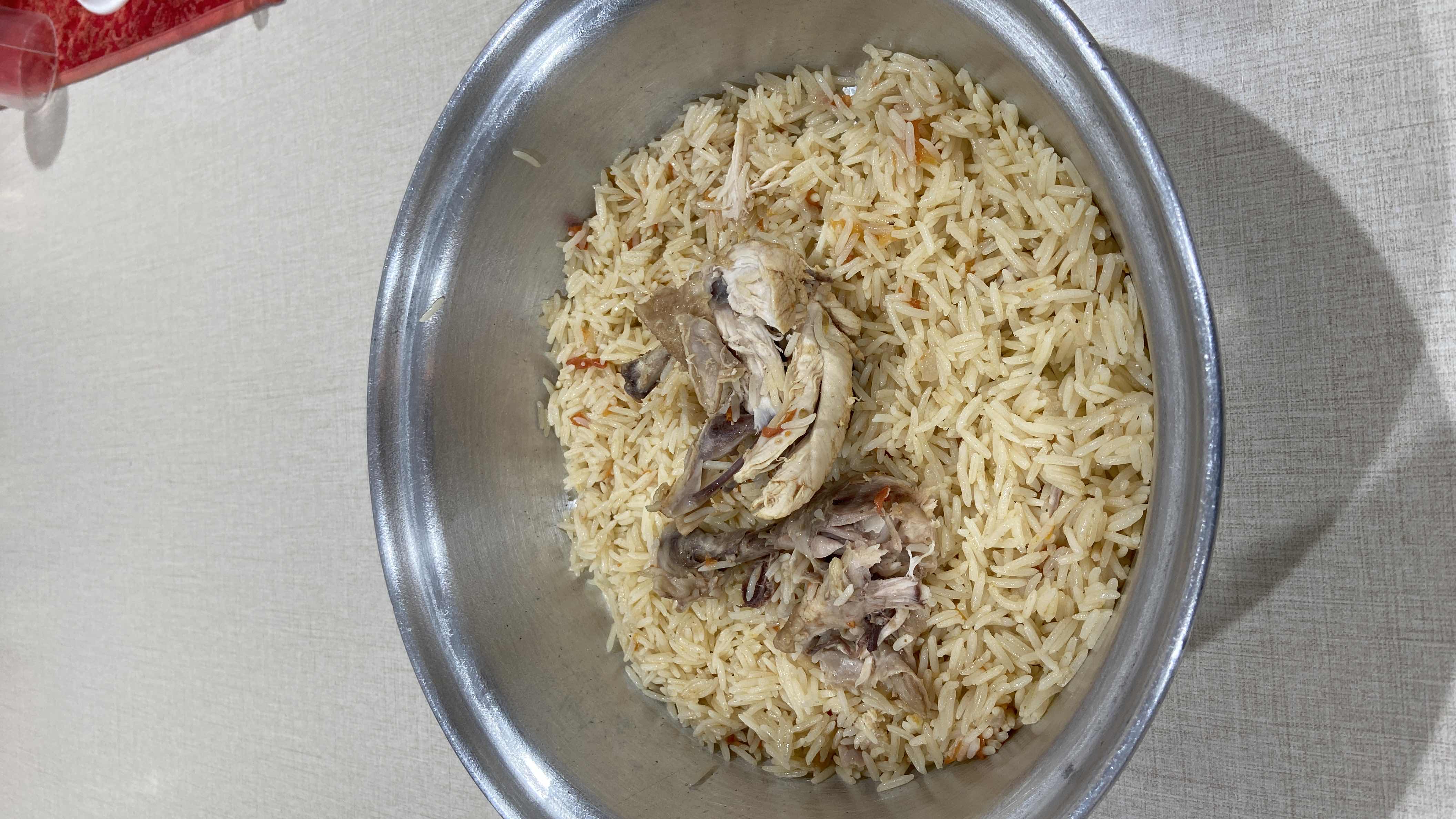 A traditional rice and chicken dish with tomatoes and oil, providing a balanced mix of protein, carbohydrates, and fats.