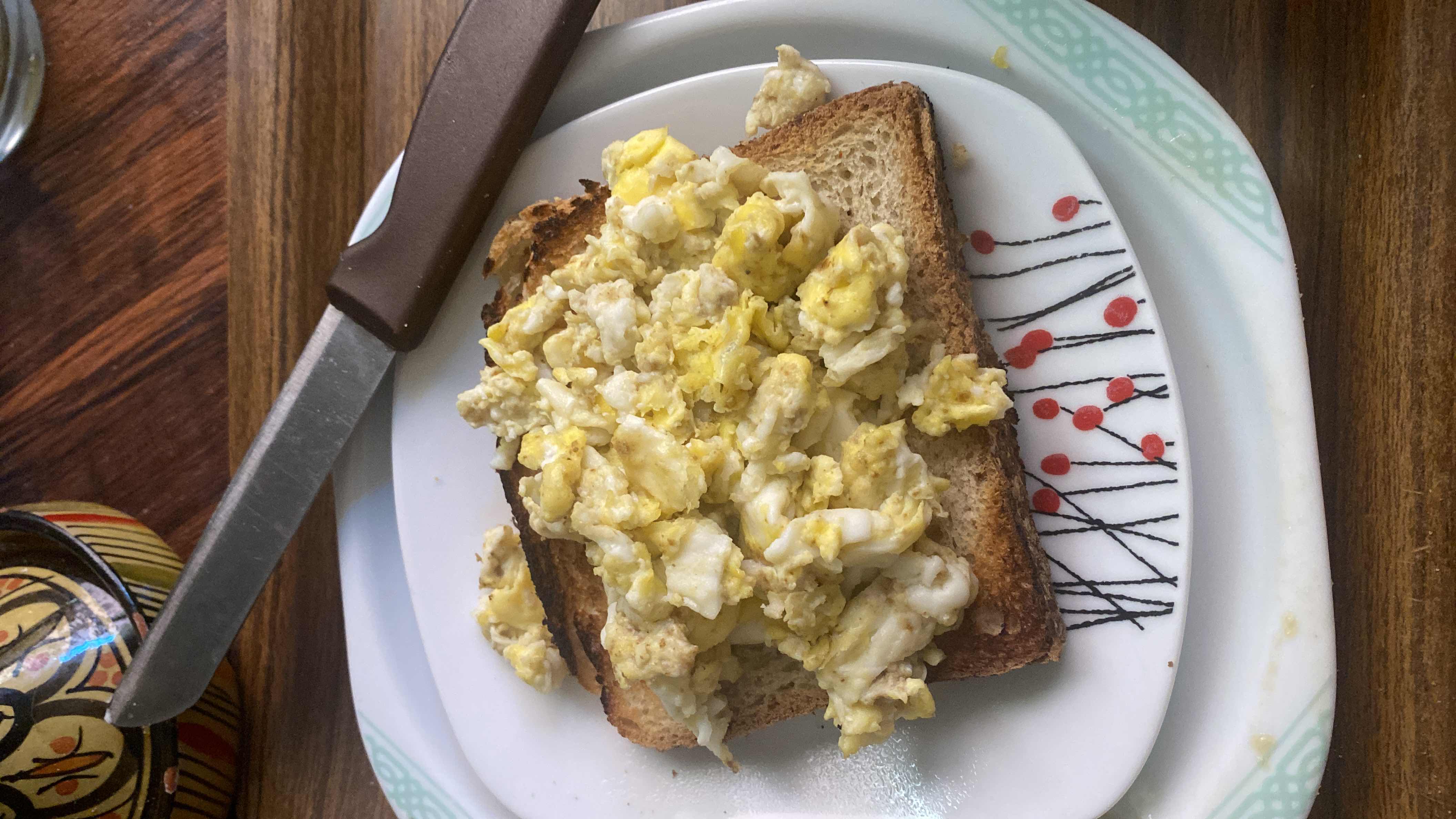 A simple meal consisting of scrambled eggs served on toasted bread, providing a balanced mix of protein, carbohydrates, and fats.