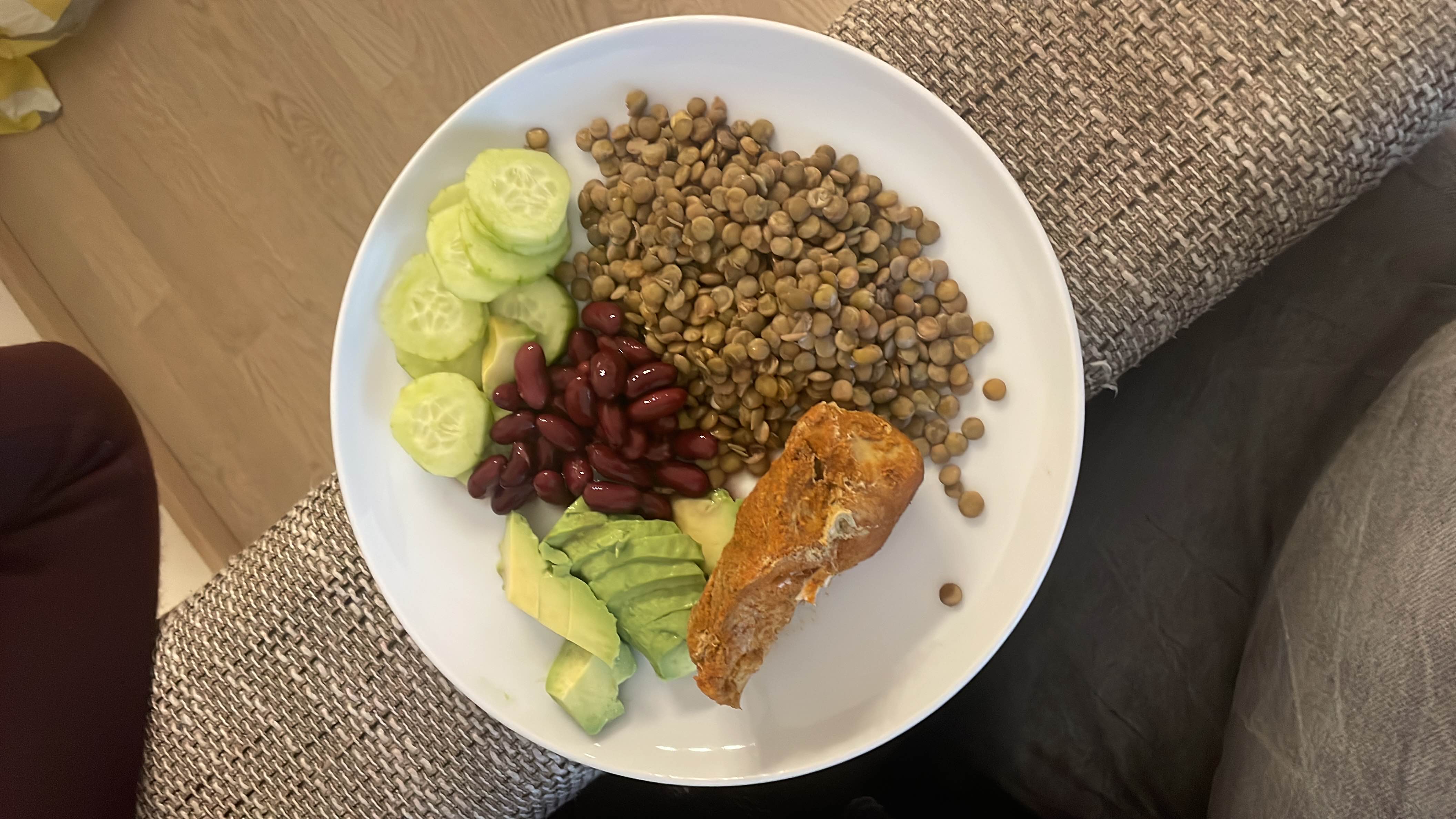 A nutritious meal consisting of lentils, kidney beans, avocado, cucumber, and chicken, providing a balanced mix of protein, carbohydrates, and healthy fats.