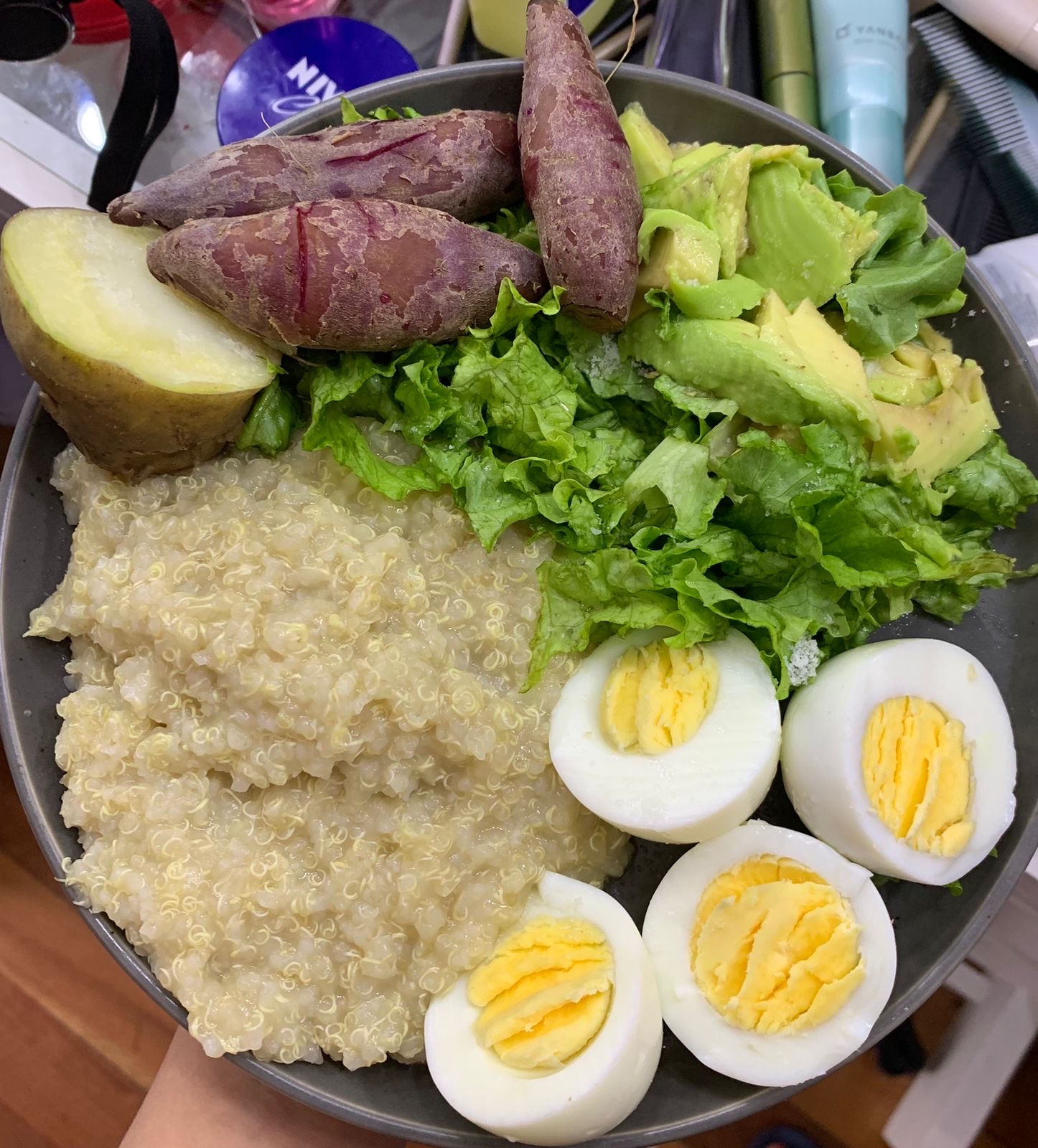 A nutritious meal consisting of quinoa, boiled eggs, sweet potatoes, avocado, and lettuce, providing a balanced mix of protein, healthy fats, and carbohydrates.