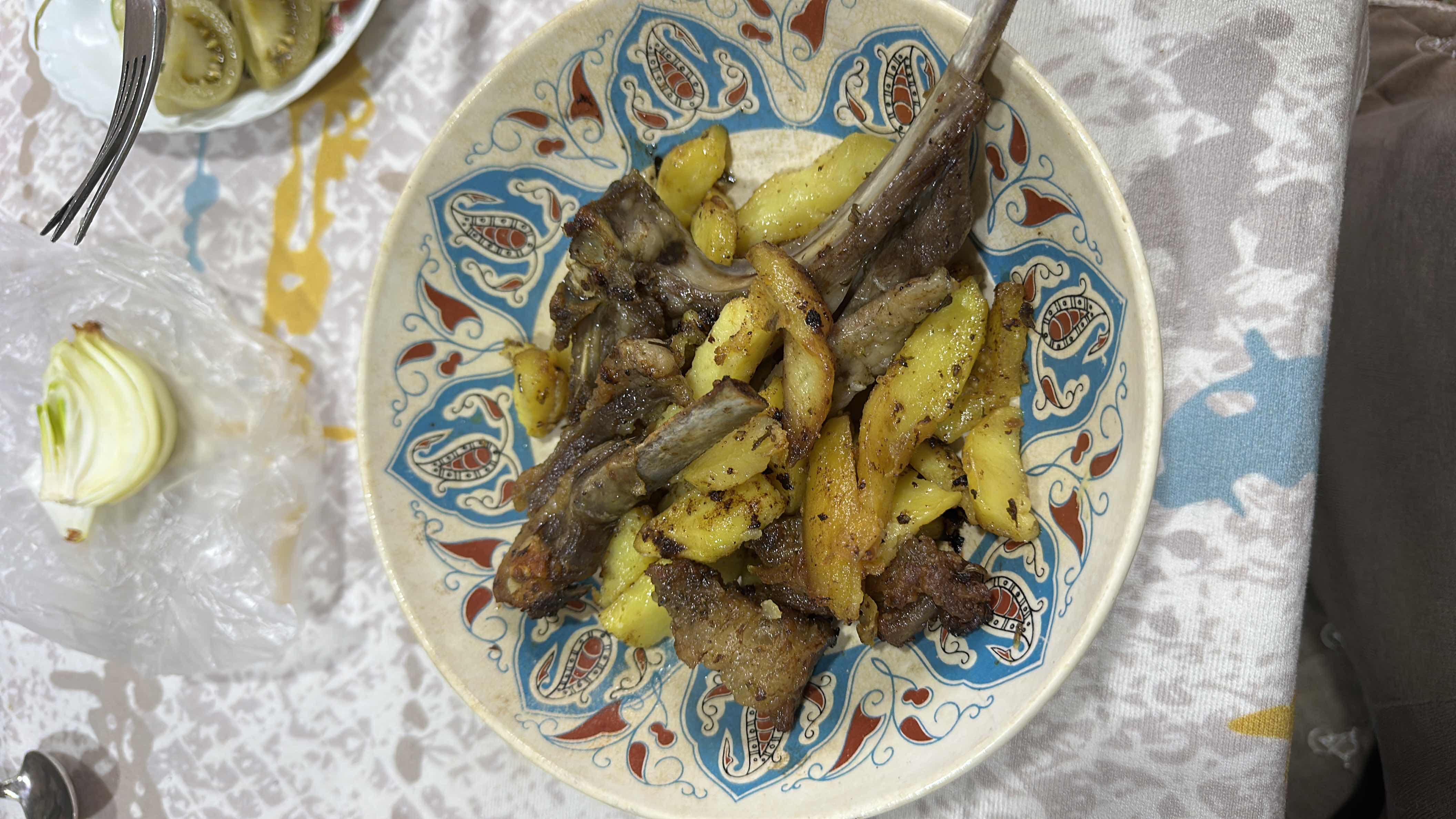 A dish consisting of grilled lamb ribs and fried potatoes, seasoned with spices and cooked to a golden brown.