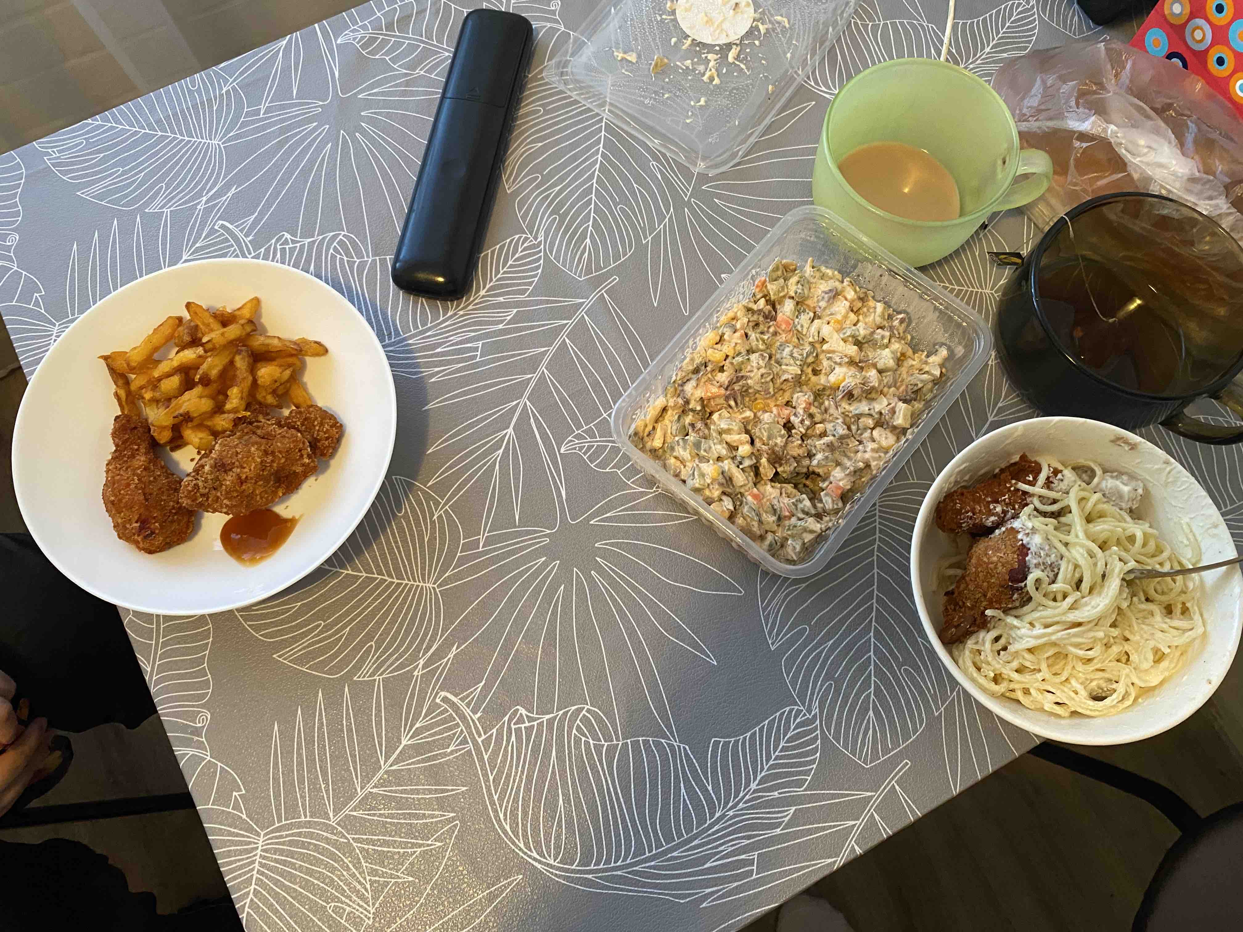 A meal consisting of fried chicken, french fries, creamy spaghetti, and a vegetable salad with mayonnaise.