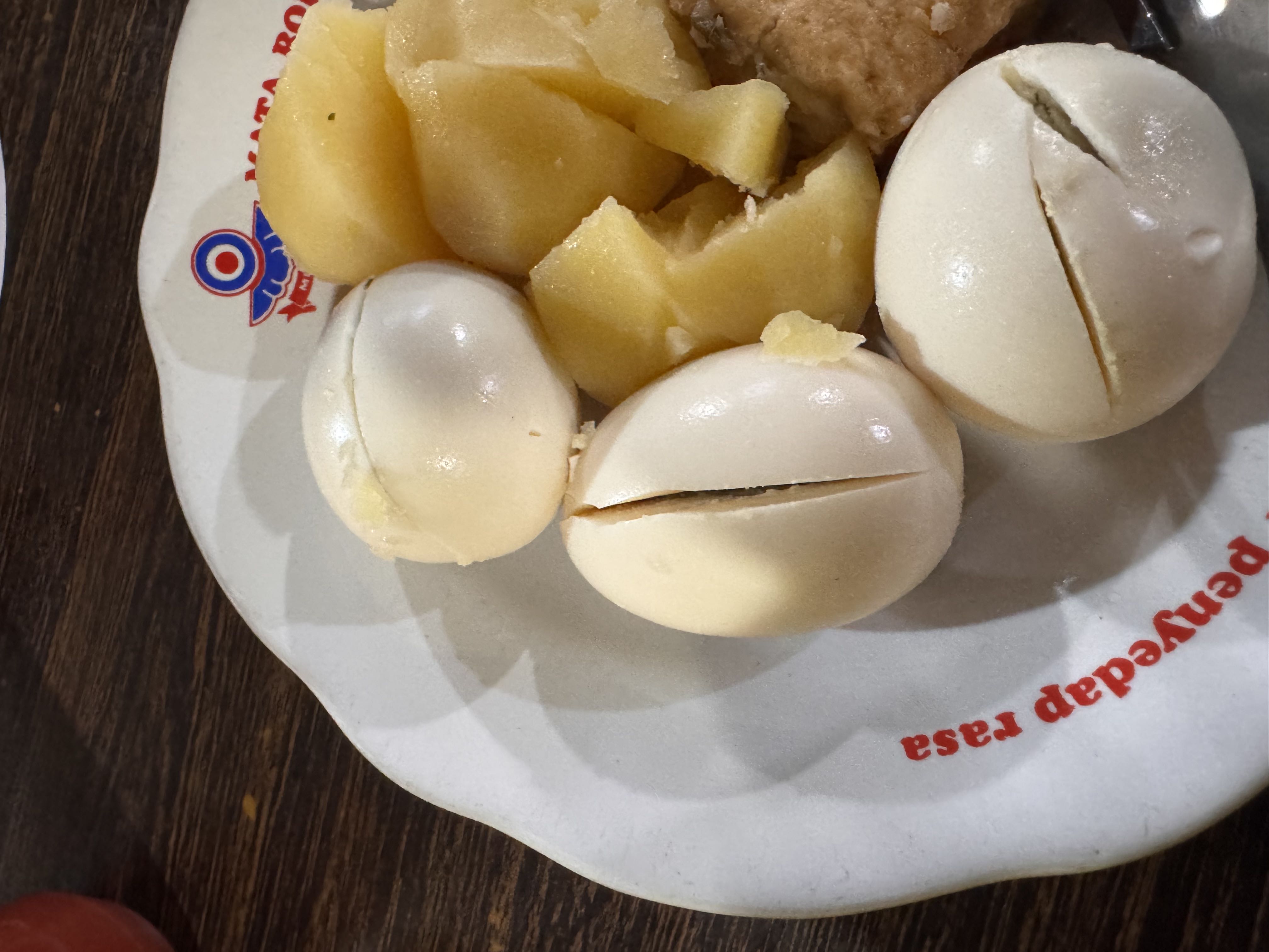 A plate containing boiled eggs, potatoes, and tofu, providing a balanced mix of protein, carbohydrates, and fats.