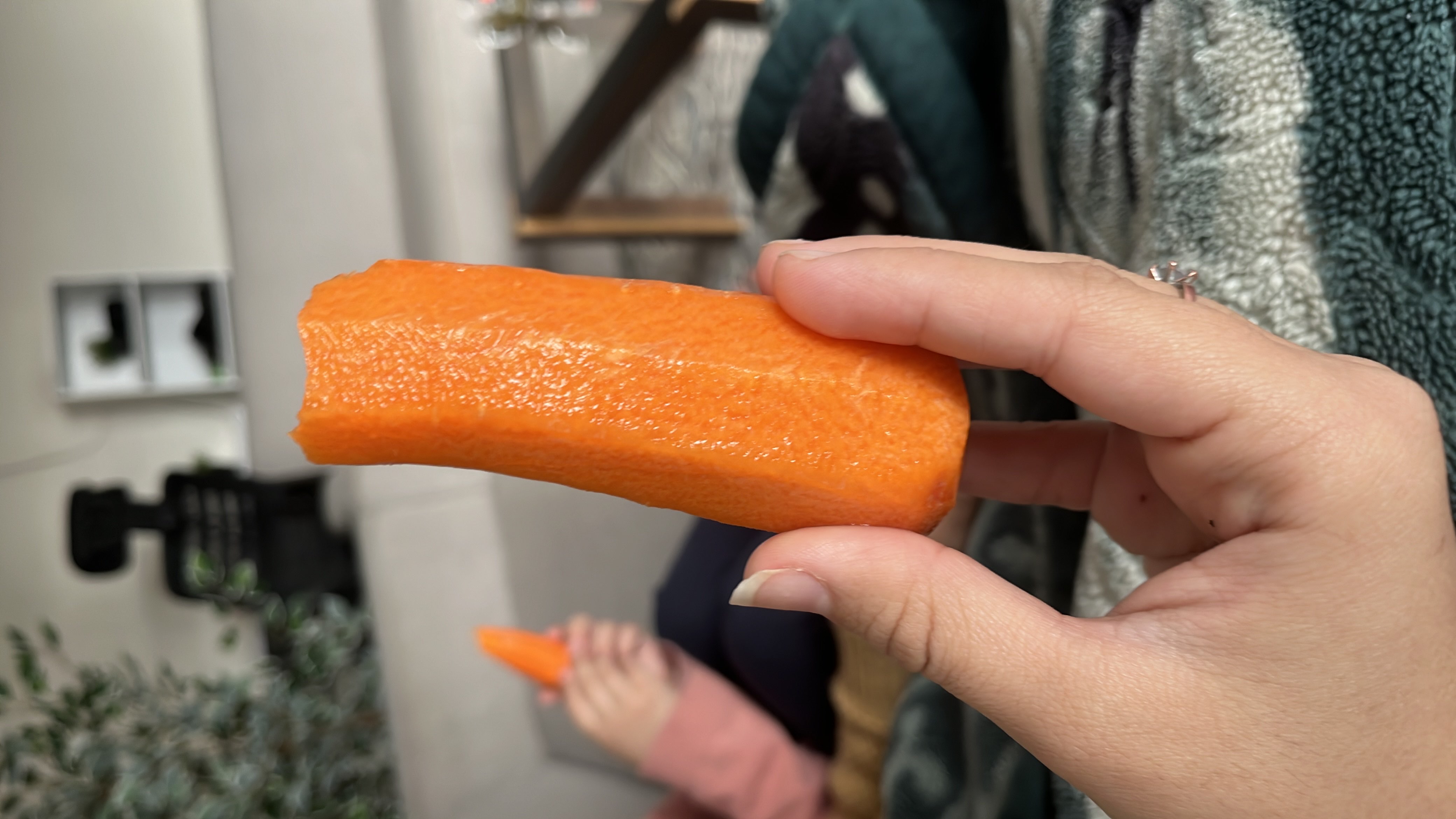 A fresh, peeled carrot being held, providing a low-calorie, nutrient-rich snack high in fiber and vitamins.