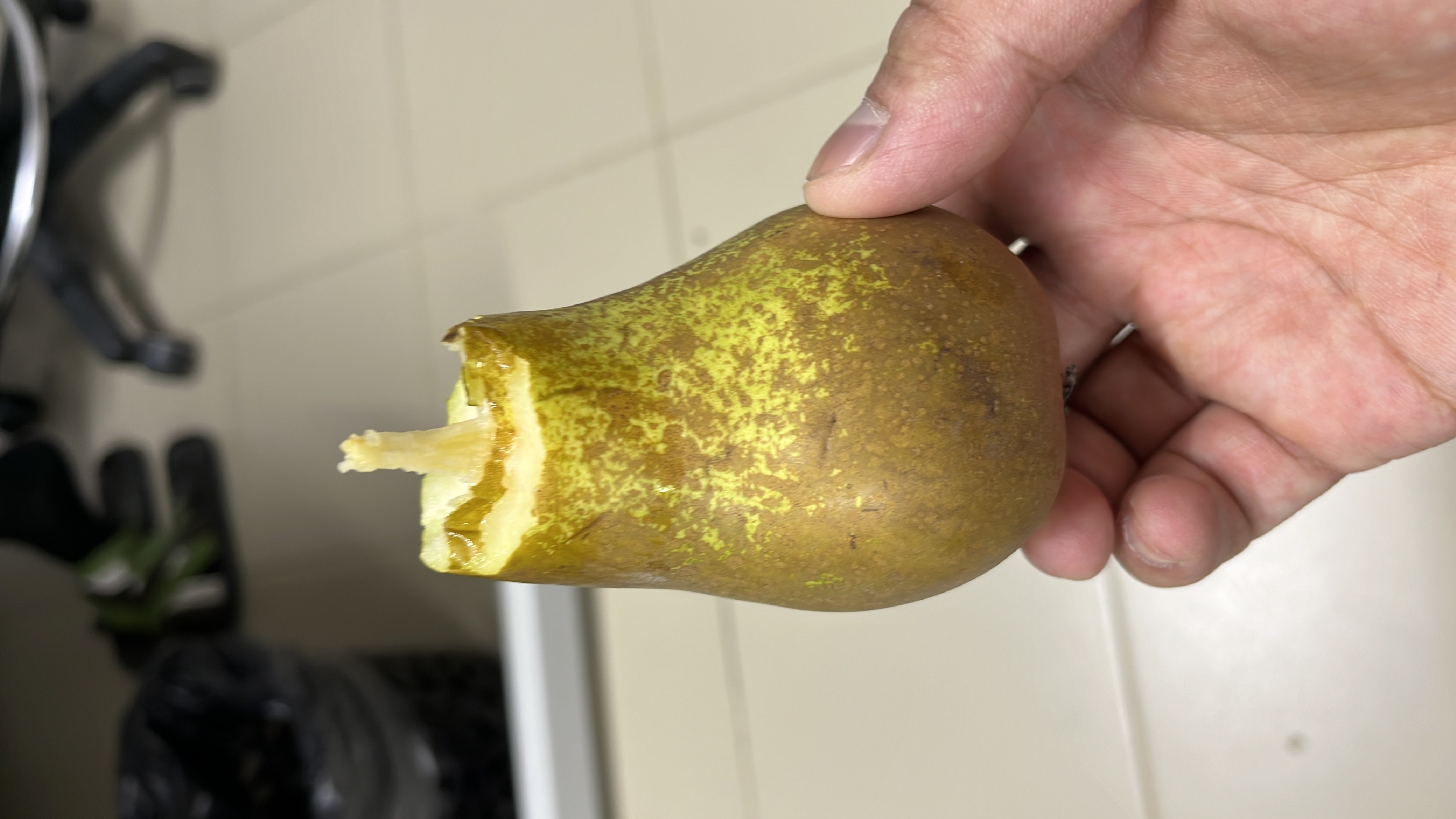 A partially eaten pear, which is a nutritious fruit rich in carbohydrates and fiber, with minimal fats and proteins.
