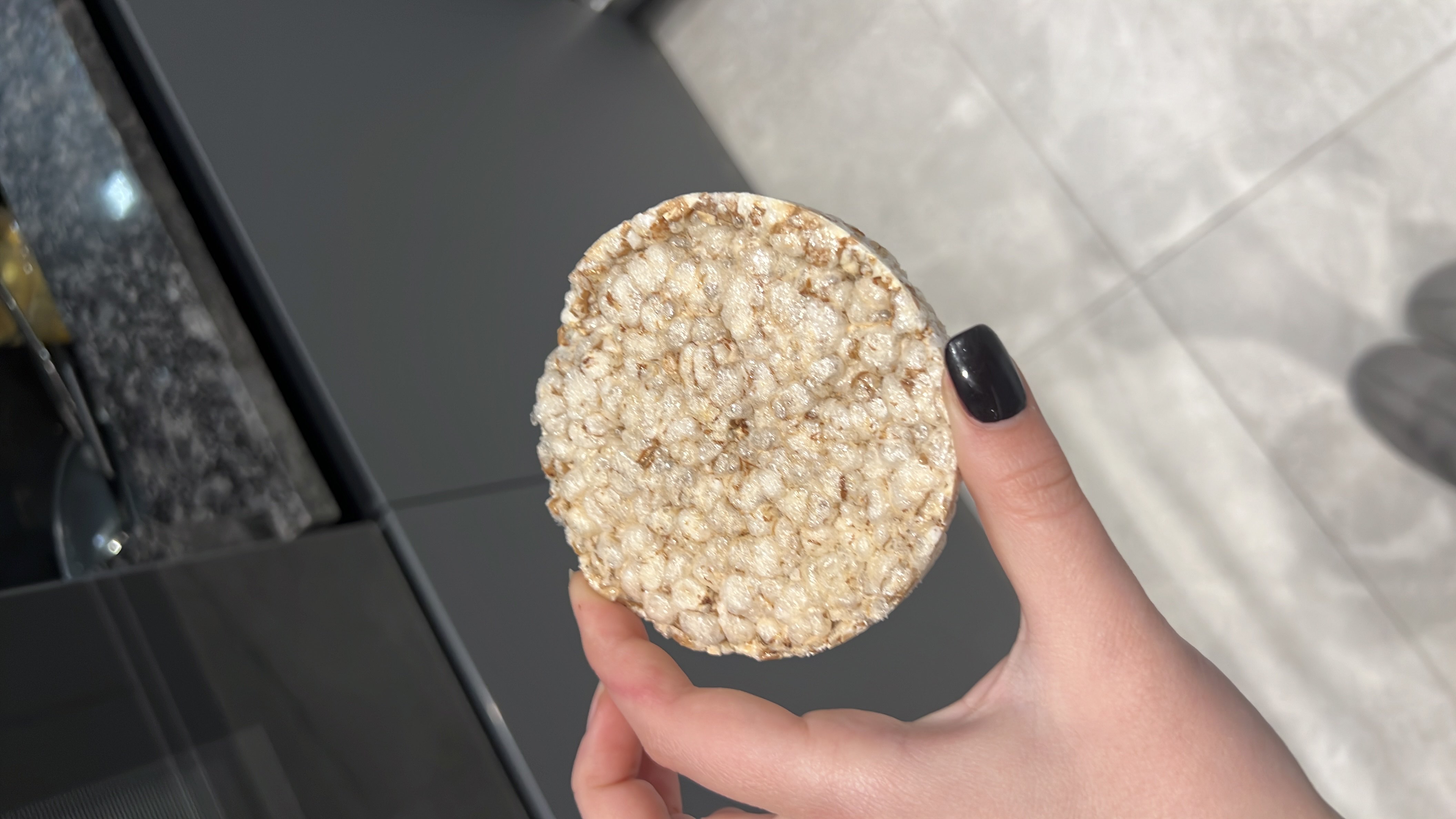 A plain rice cake, a low-calorie snack primarily made of puffed rice, providing minimal fats and protein with a high carbohydrate content.