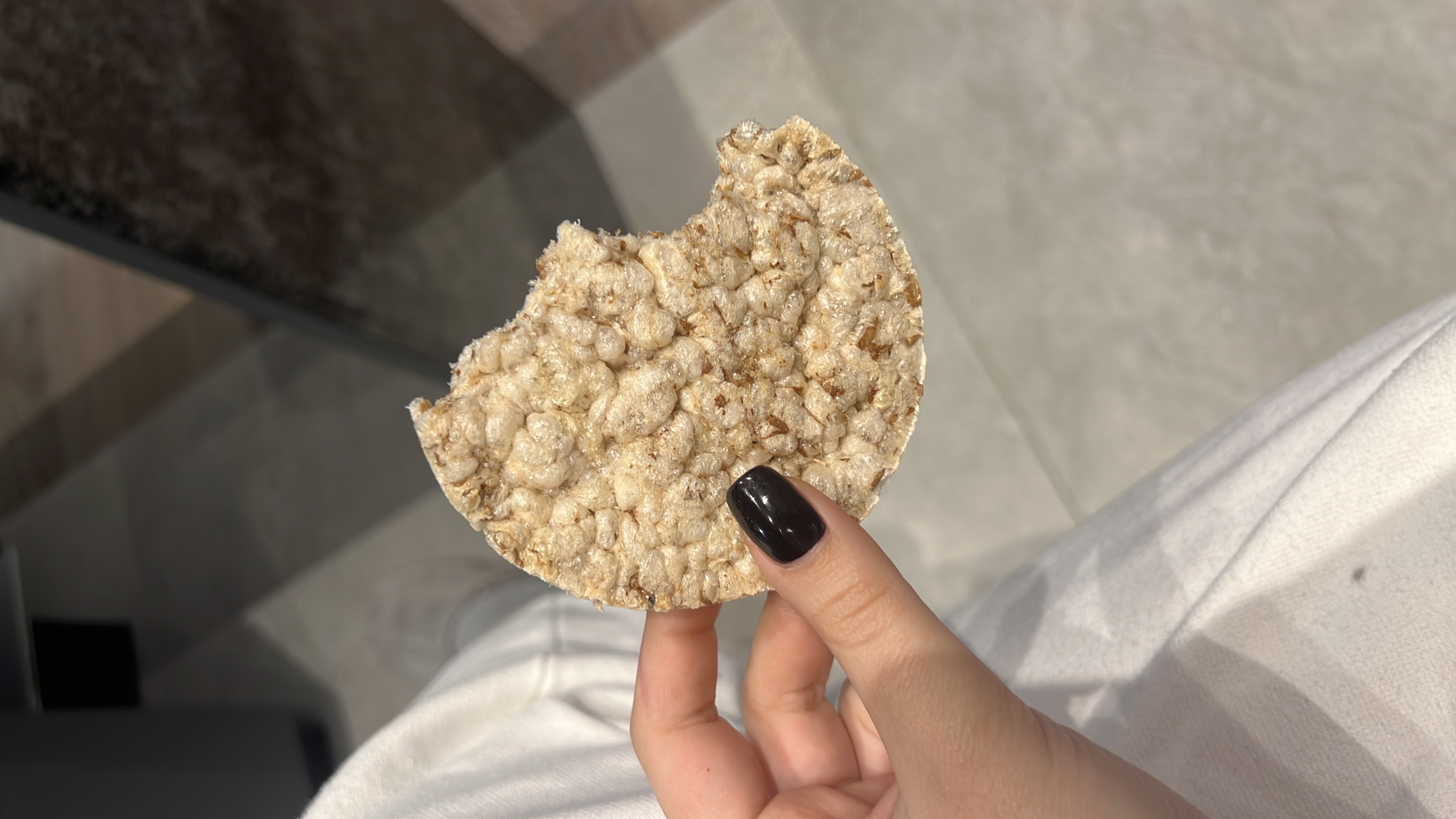 A plain rice cake, a low-calorie snack primarily made of puffed rice, providing minimal fats and moderate carbohydrates.
