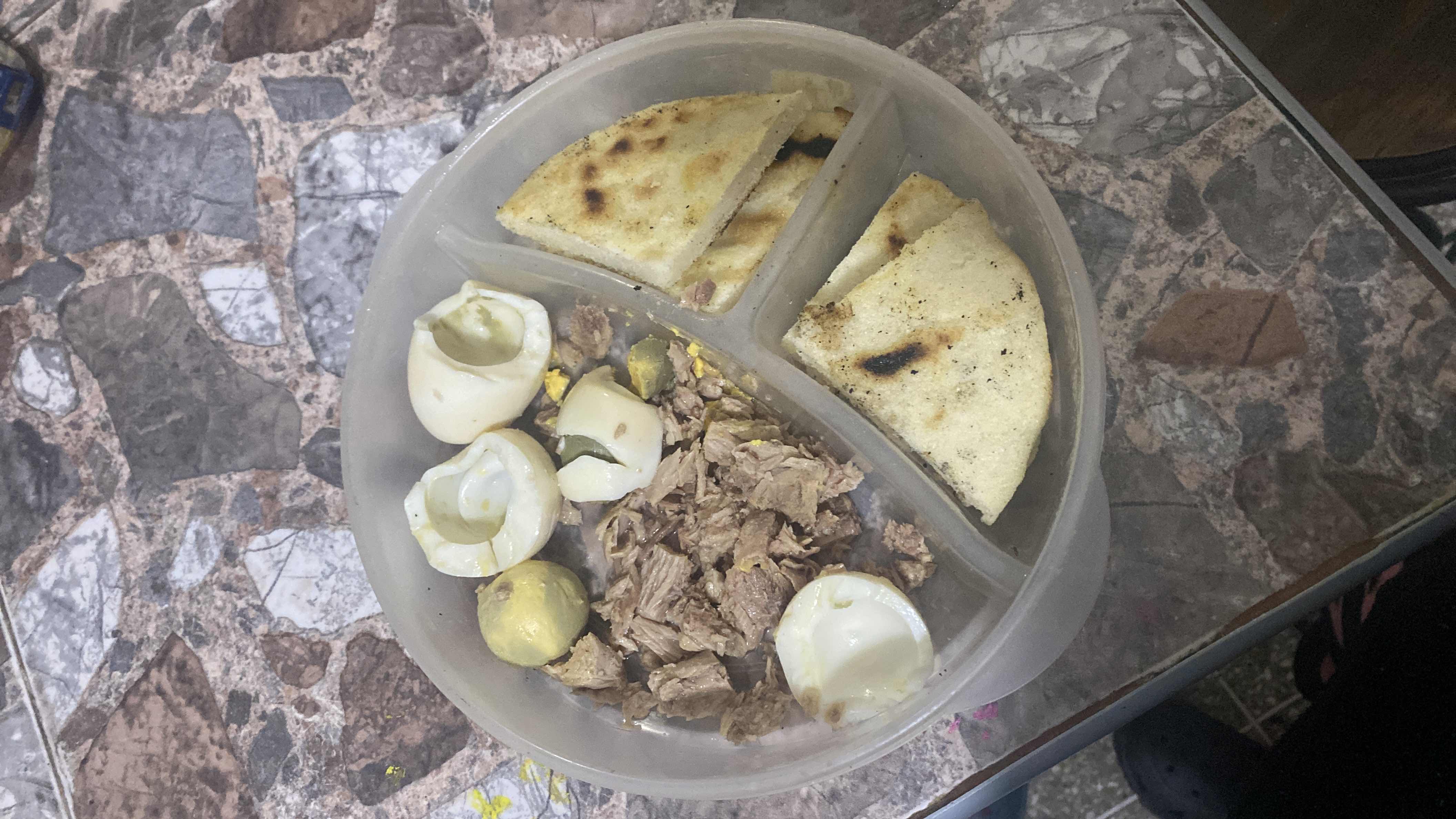 A balanced meal consisting of tuna, boiled eggs, and flatbread, providing a good mix of protein, carbohydrates, and fats.