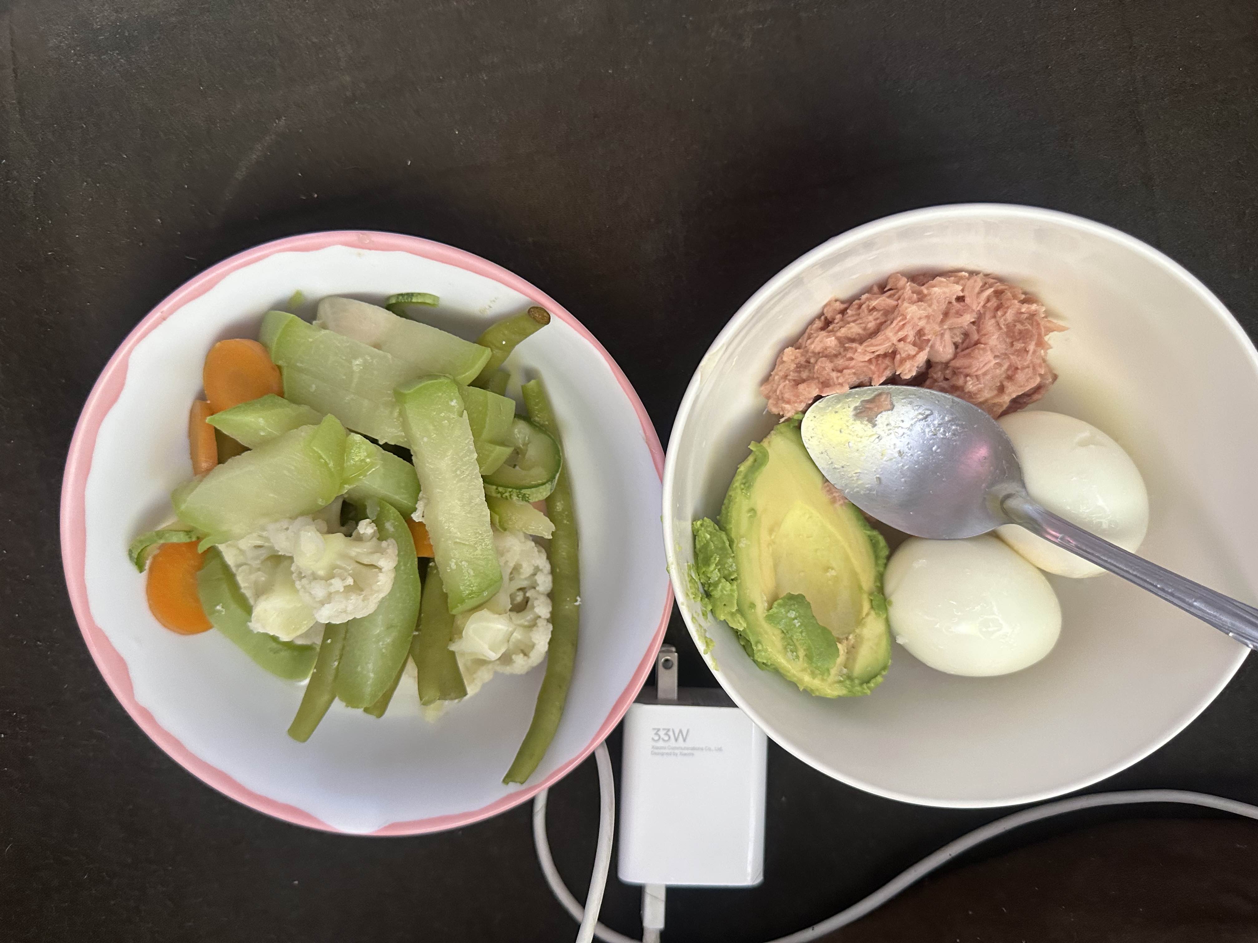 A balanced meal consisting of boiled eggs, avocado, tuna, and steamed vegetables, providing a good mix of protein, healthy fats, and fiber.