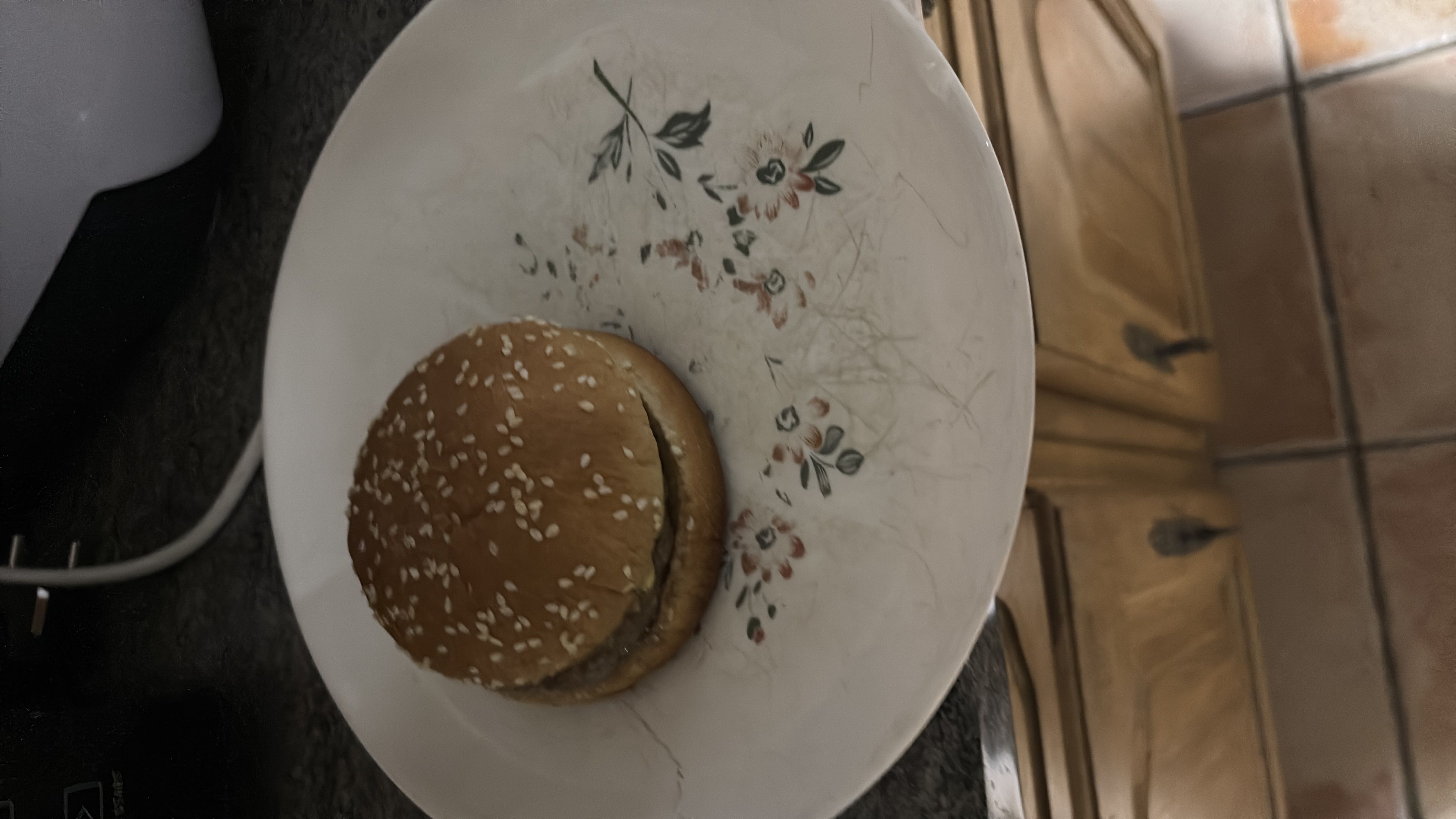 A simple hamburger with a sesame seed bun and beef patty, providing a moderate amount of protein and carbohydrates.
