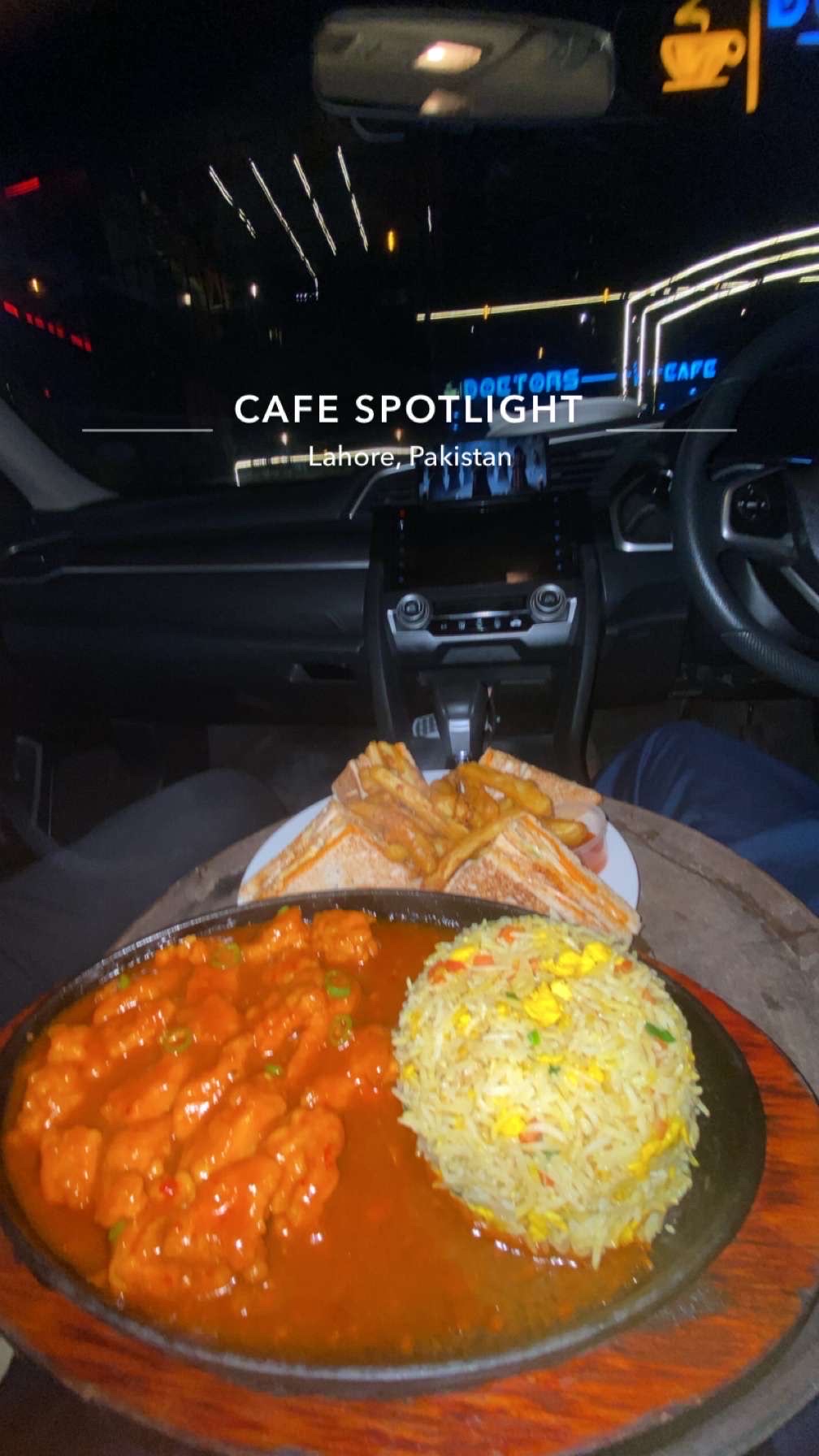A meal consisting of fried rice with vegetables, chicken in red sauce, grilled sandwiches, and french fries, served on a sizzling platter.