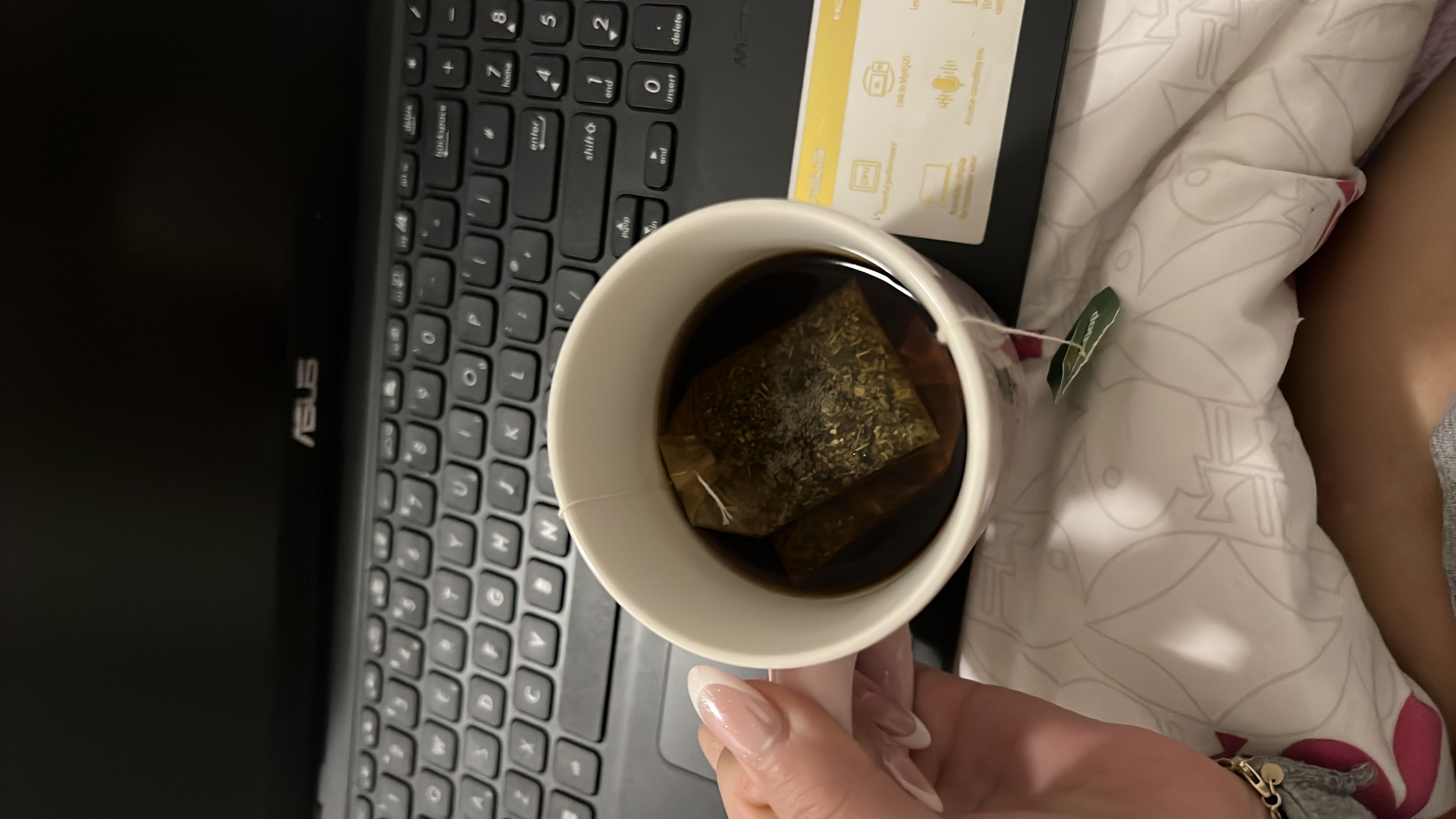 A cup of black tea with a tea bag, containing minimal calories and no macronutrients, making it a healthy beverage choice.