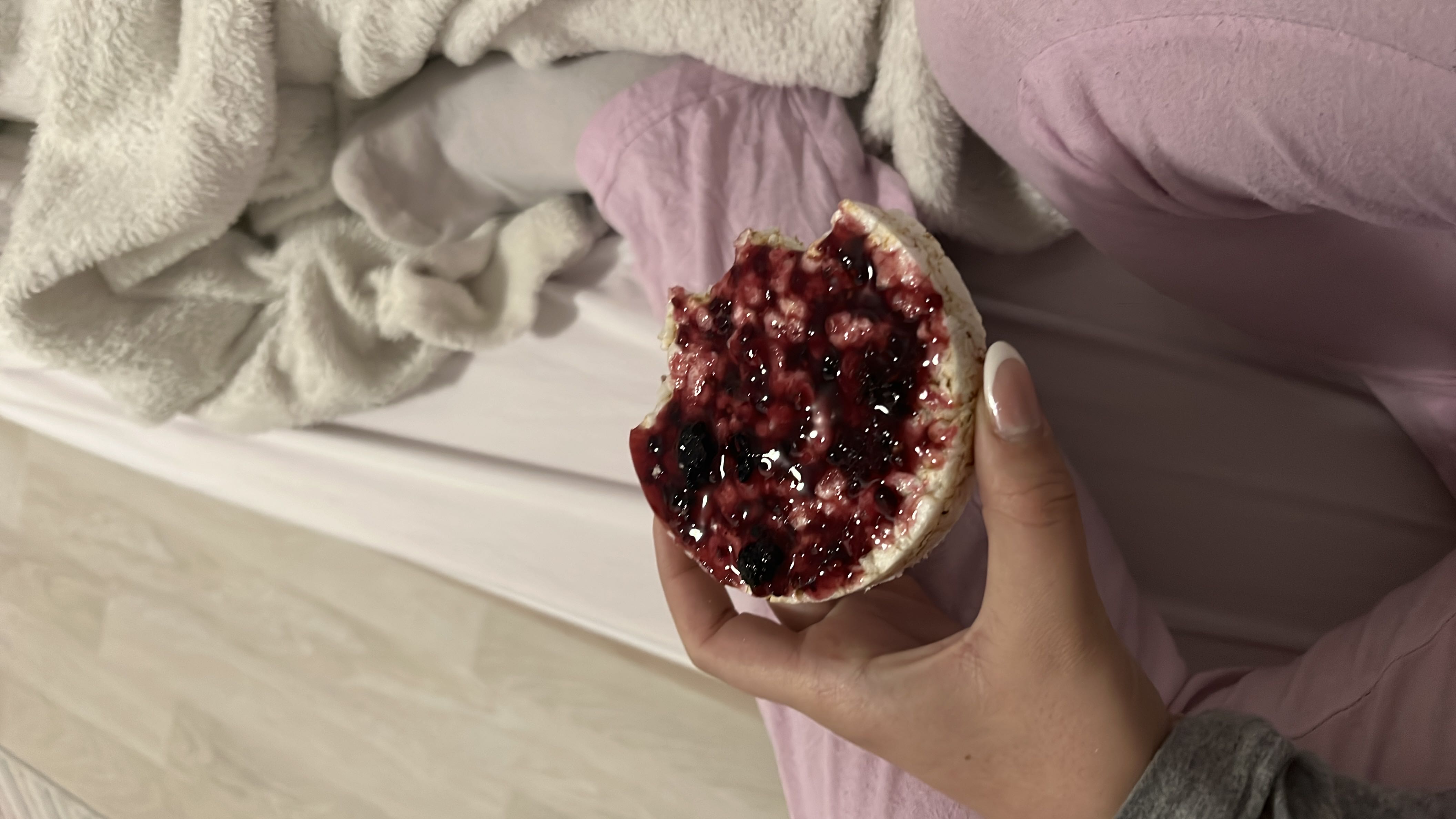 A rice cake topped with berry jam, providing a light and low-calorie snack with moderate carbohydrates and minimal fats.