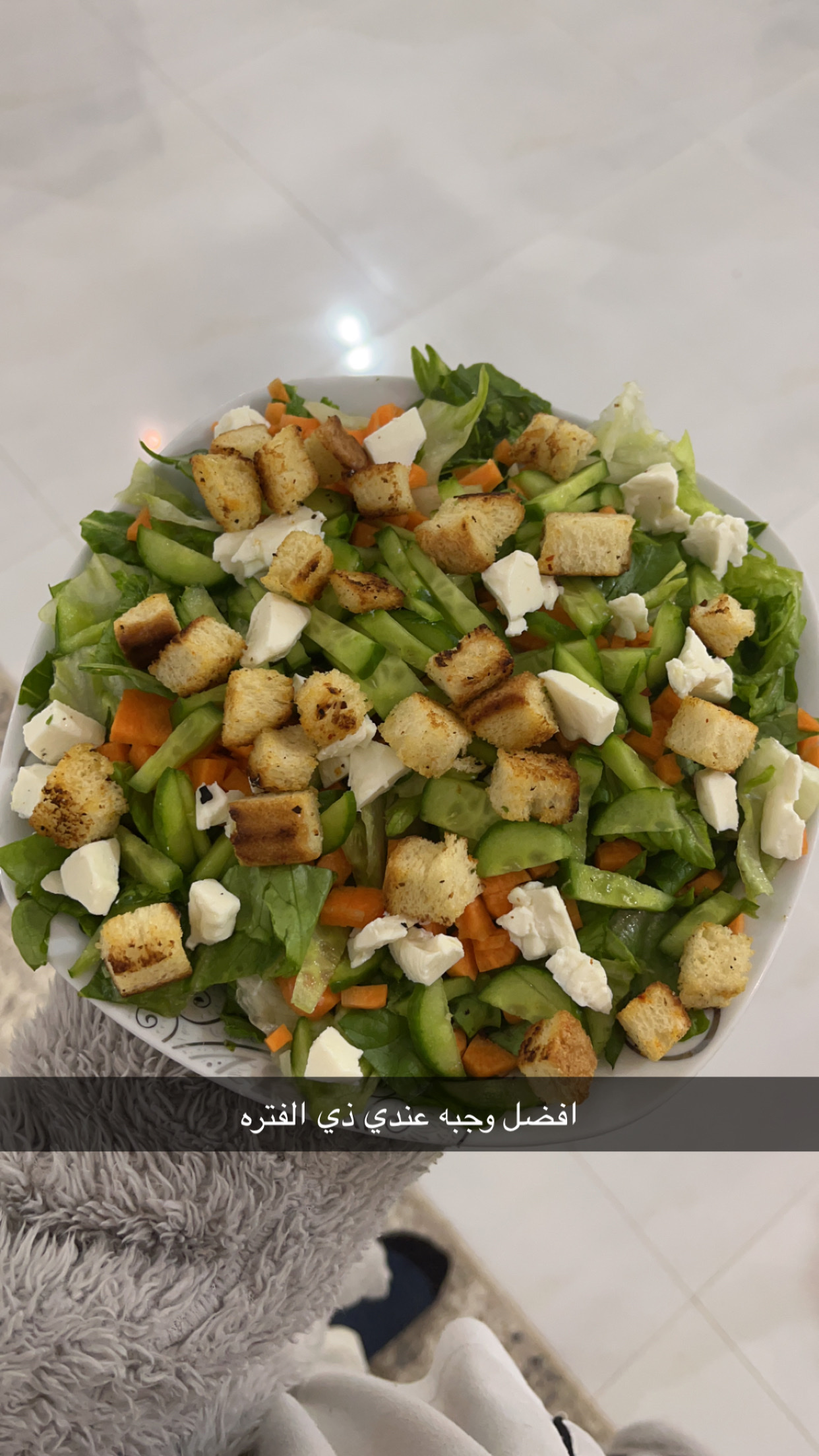 A fresh vegetable salad with lettuce, cucumber, carrots, feta cheese, and croutons, providing a balanced mix of protein, carbs, and fats.