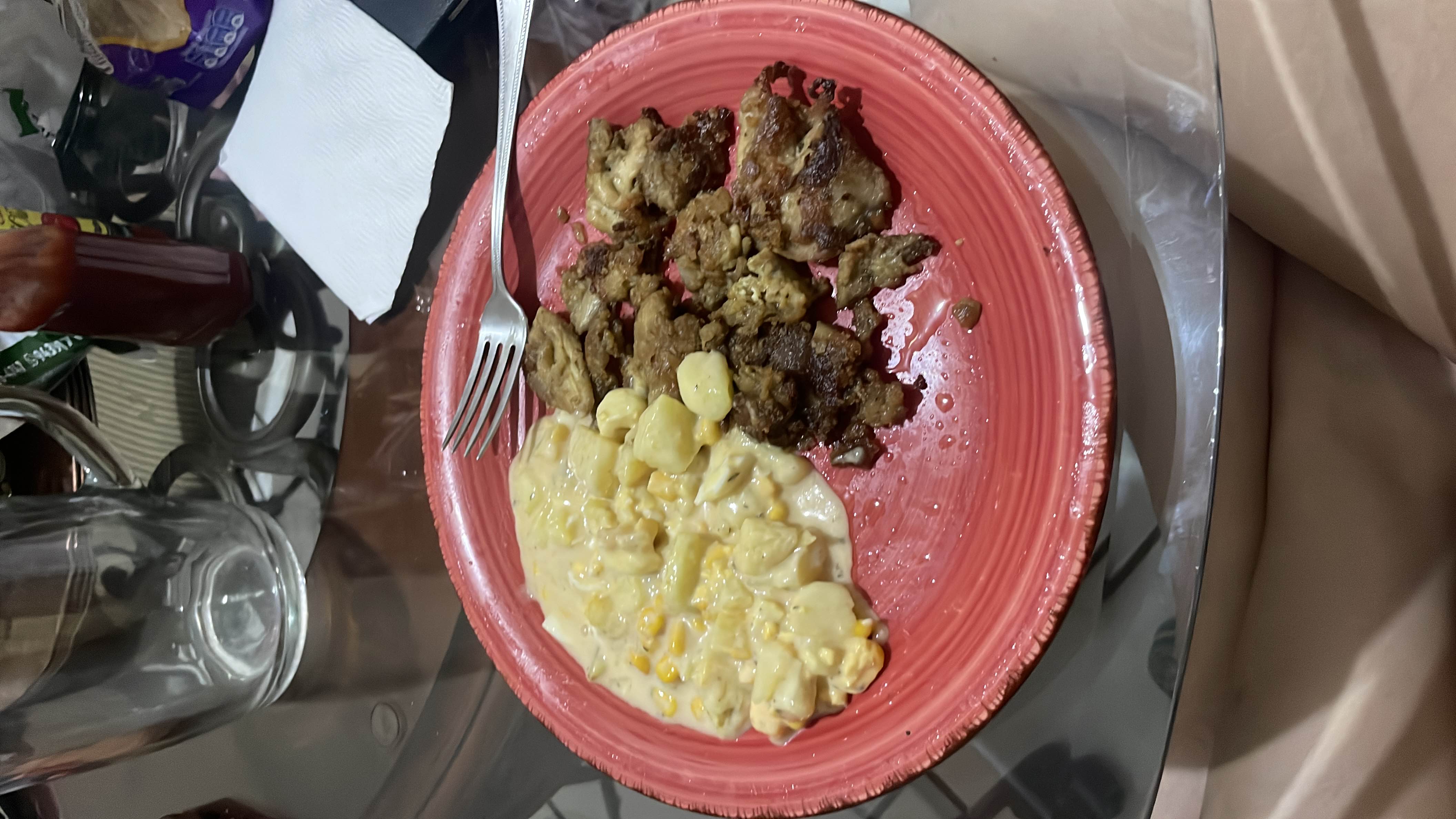 A meal consisting of cooked beef pieces and a creamy cheesy pasta with corn, providing a balanced mix of protein, fats, and carbohydrates.