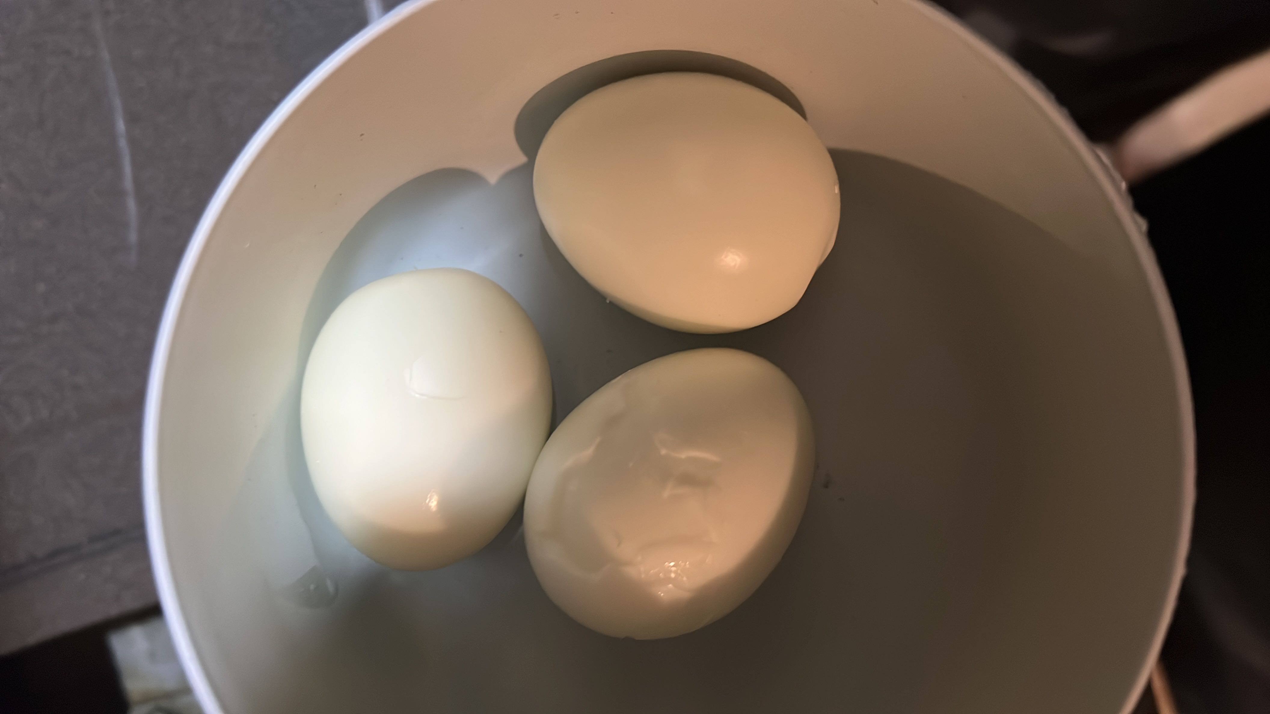 A bowl containing three boiled eggs, which are a high-protein, low-carb food with healthy fats.