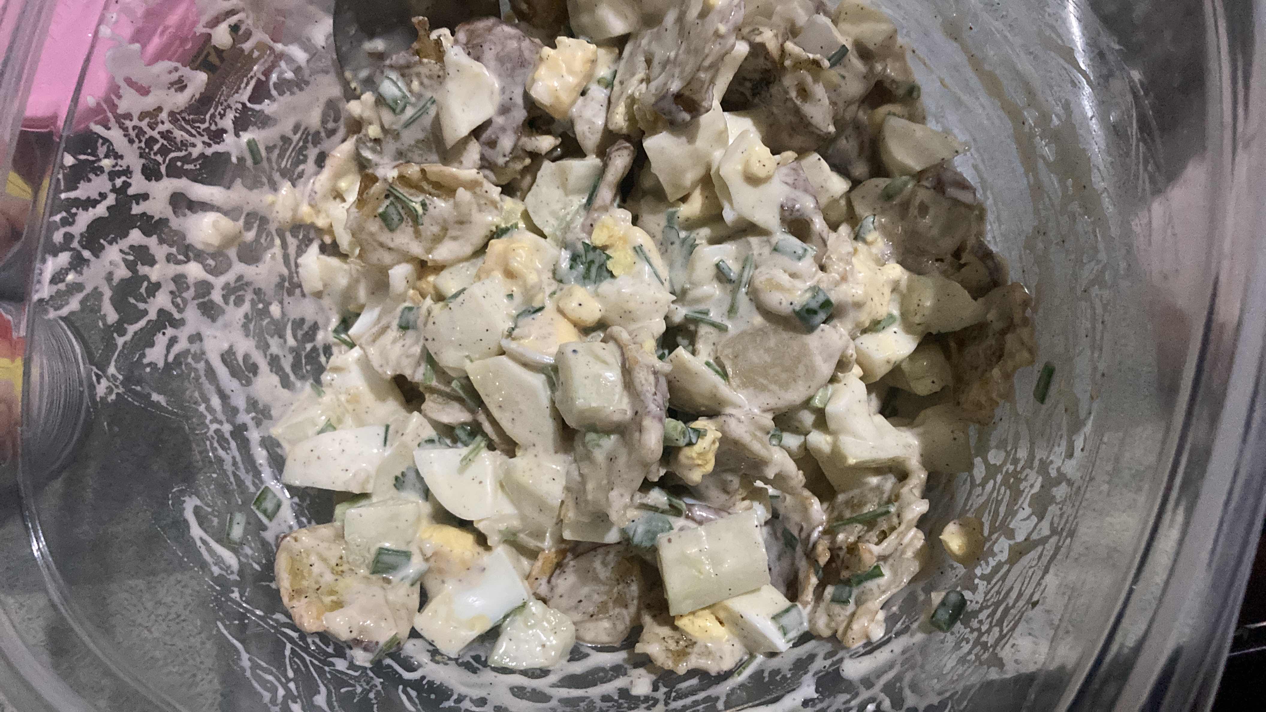 A creamy potato and egg salad with mayonnaise, green onions, and cucumbers, offering a balanced mix of protein, carbs, and fats.