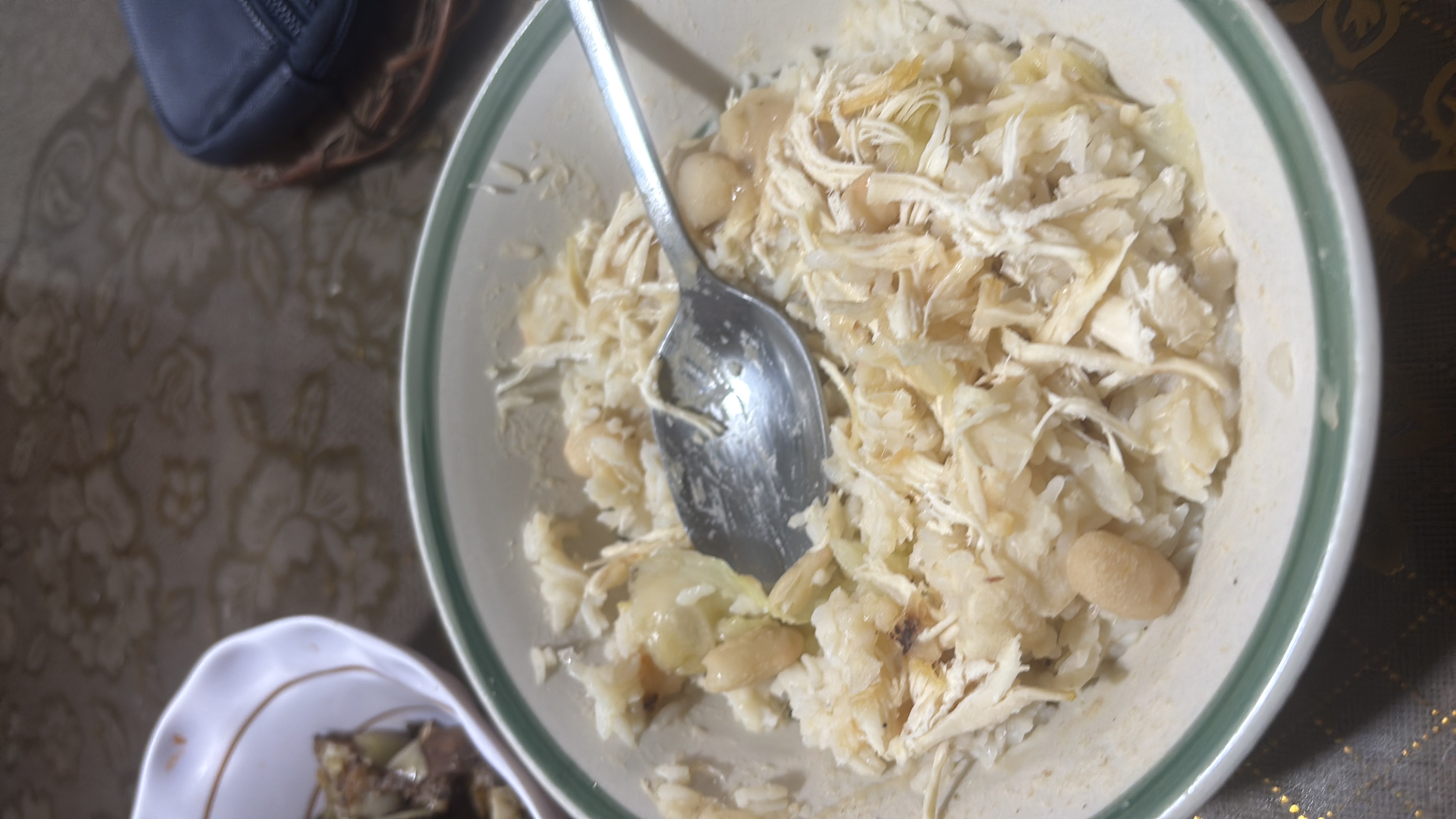 A nutritious dish consisting of rice, shredded chicken, and white beans, providing a balanced mix of protein, carbohydrates, and fats.