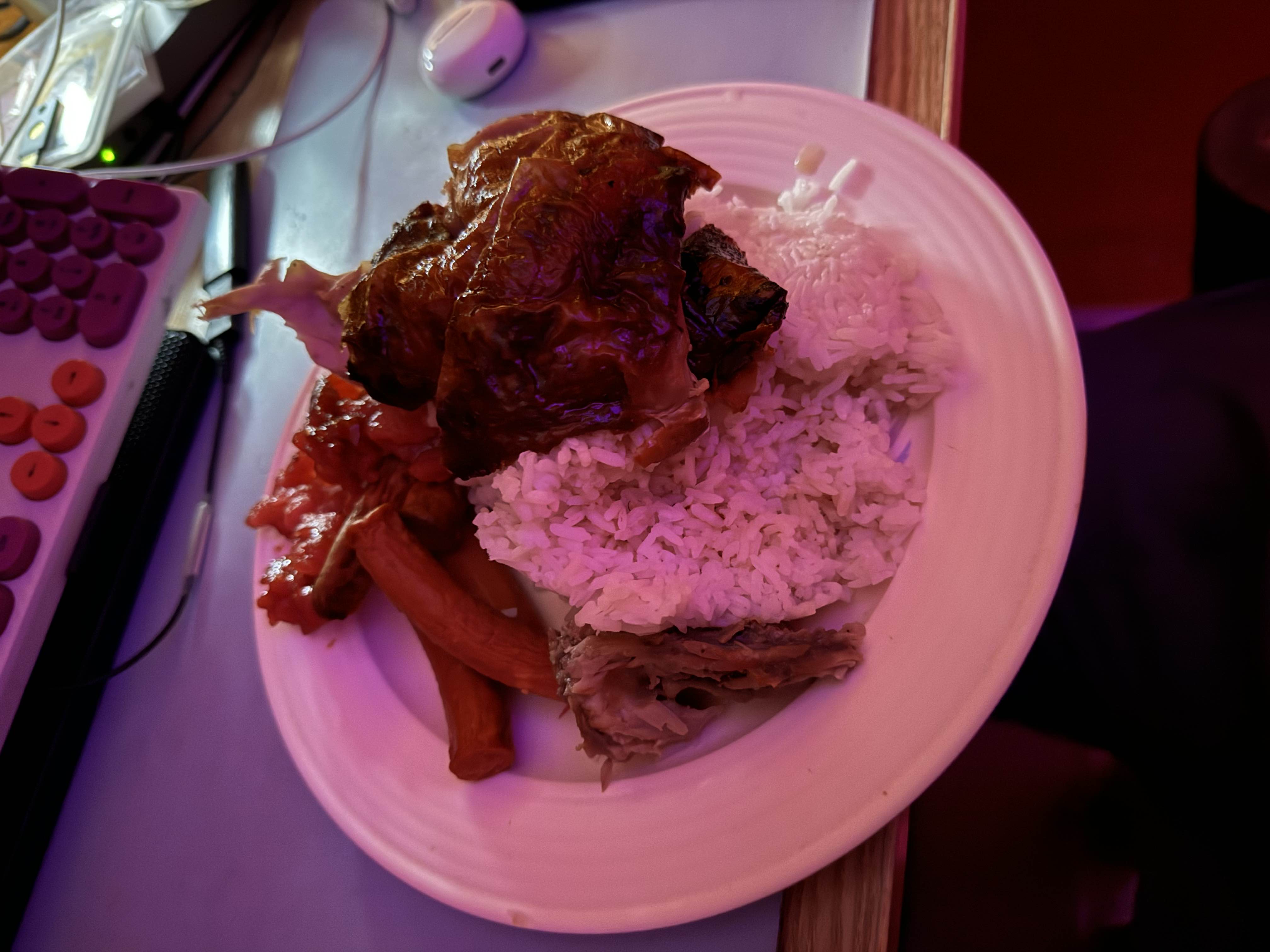 A plate containing white rice, roasted chicken, and sausages, providing a balanced mix of protein, carbohydrates, and fats.