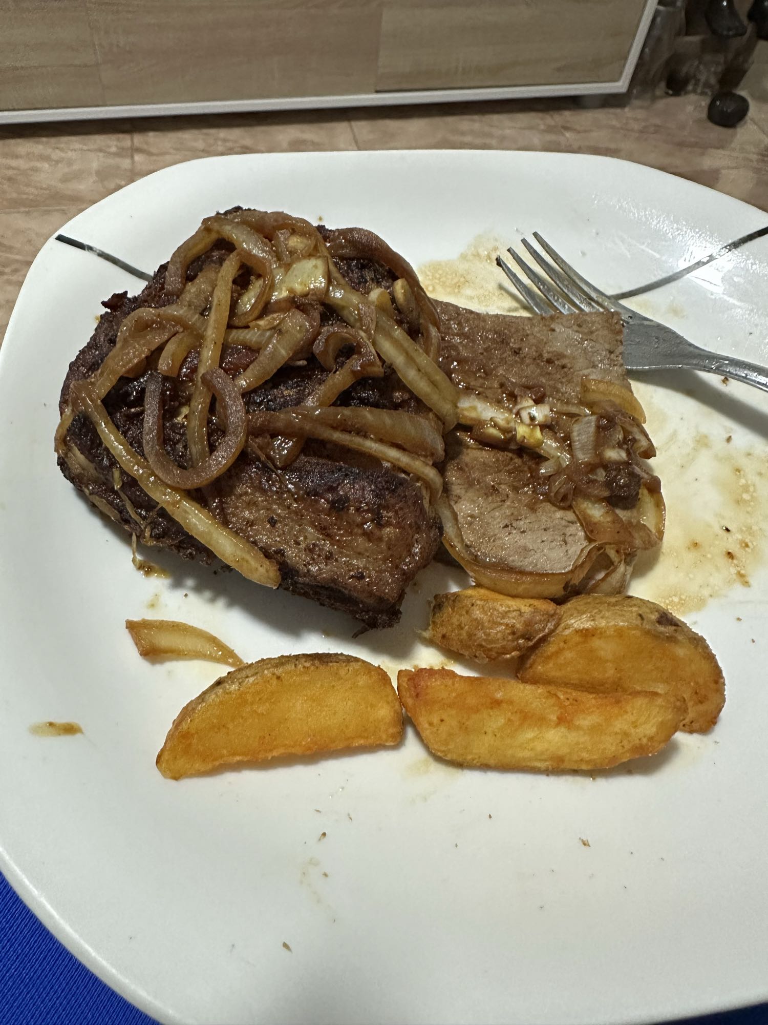 Bistec encebollado con papas