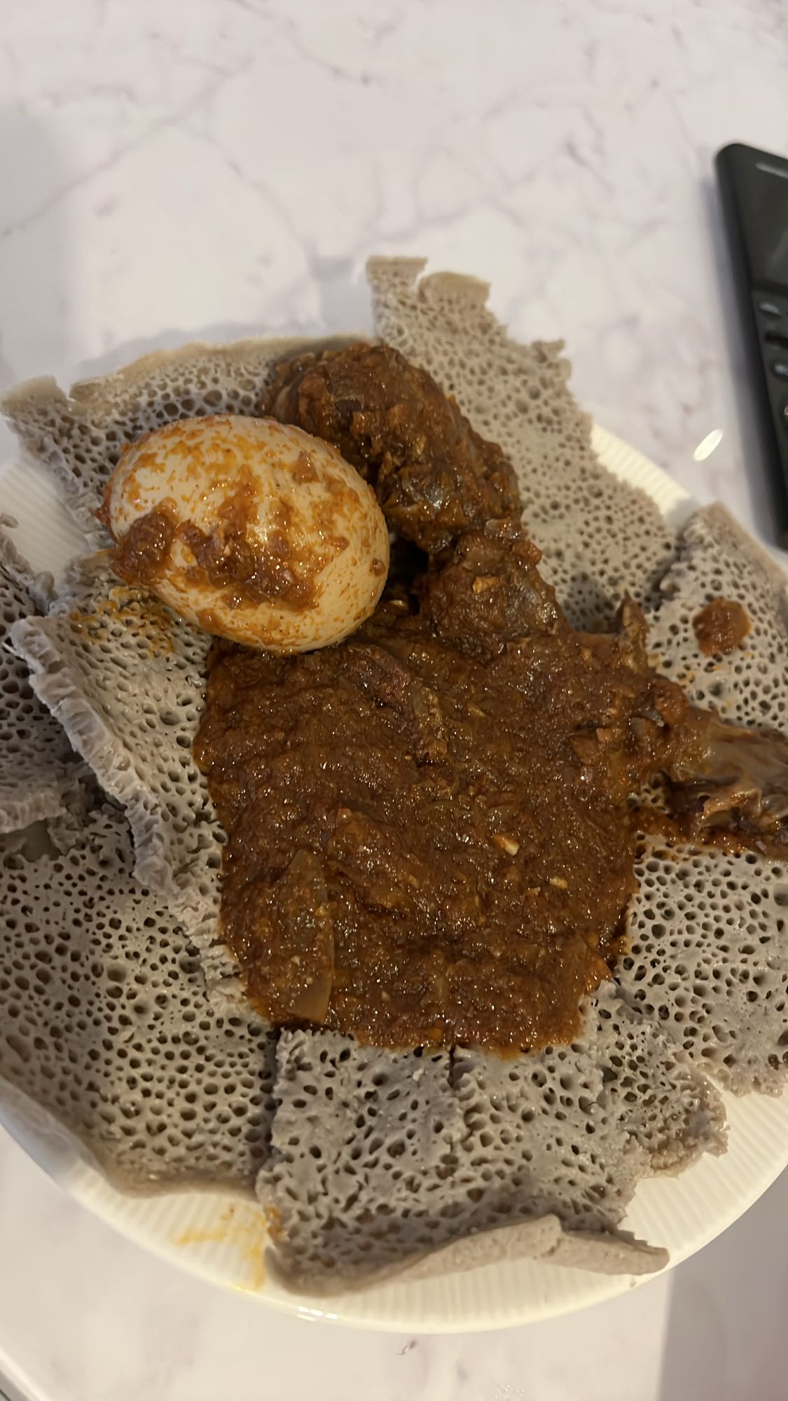 Injera with stew and egg