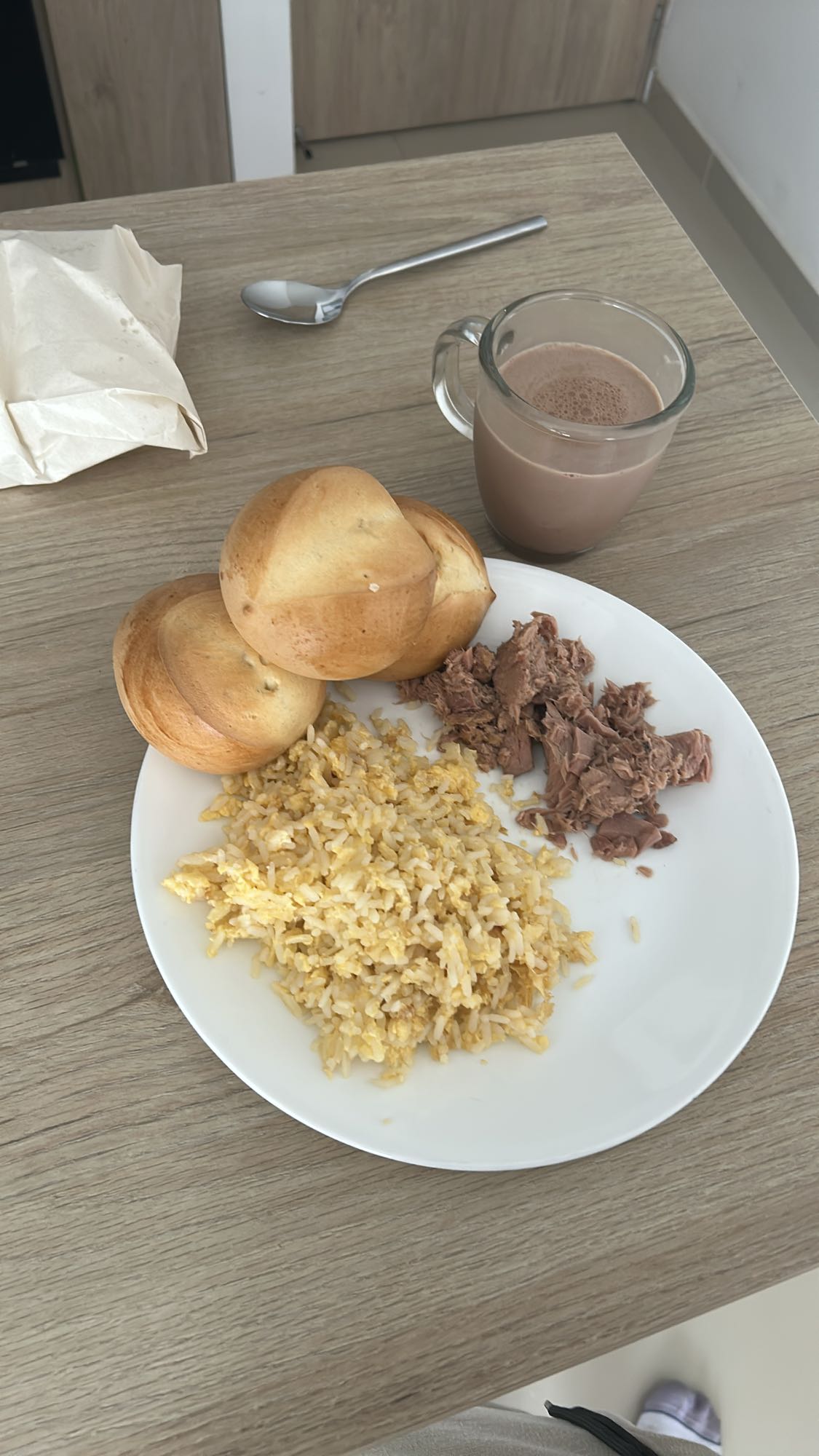 Huevos con arroz, atún, chocolate con leche y panecillos