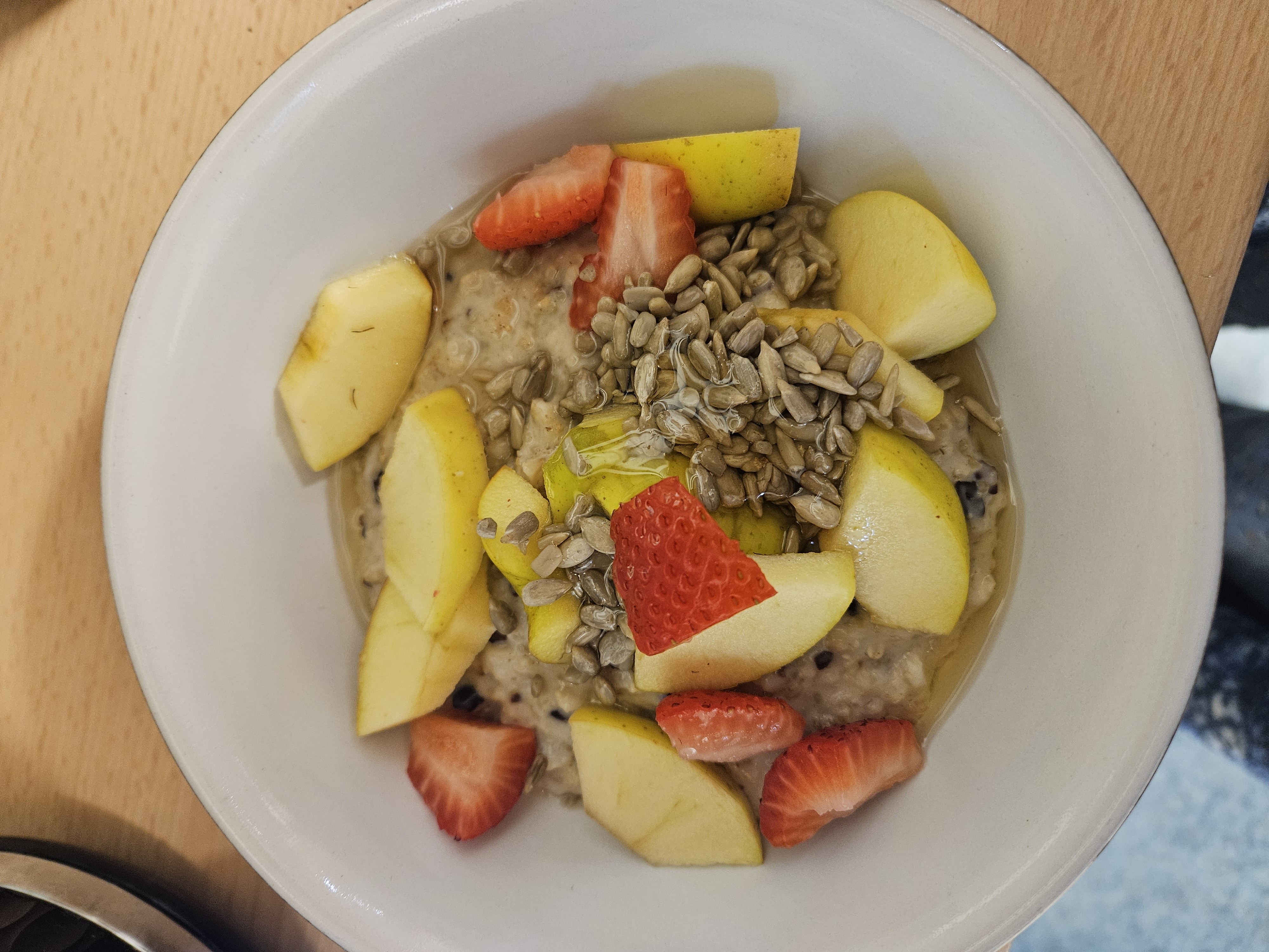 Oatmeal with fruit, seeds, milk, and cacao nibs