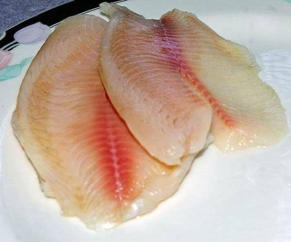 filetes de pescado crudo con una papa chica y zanahoria