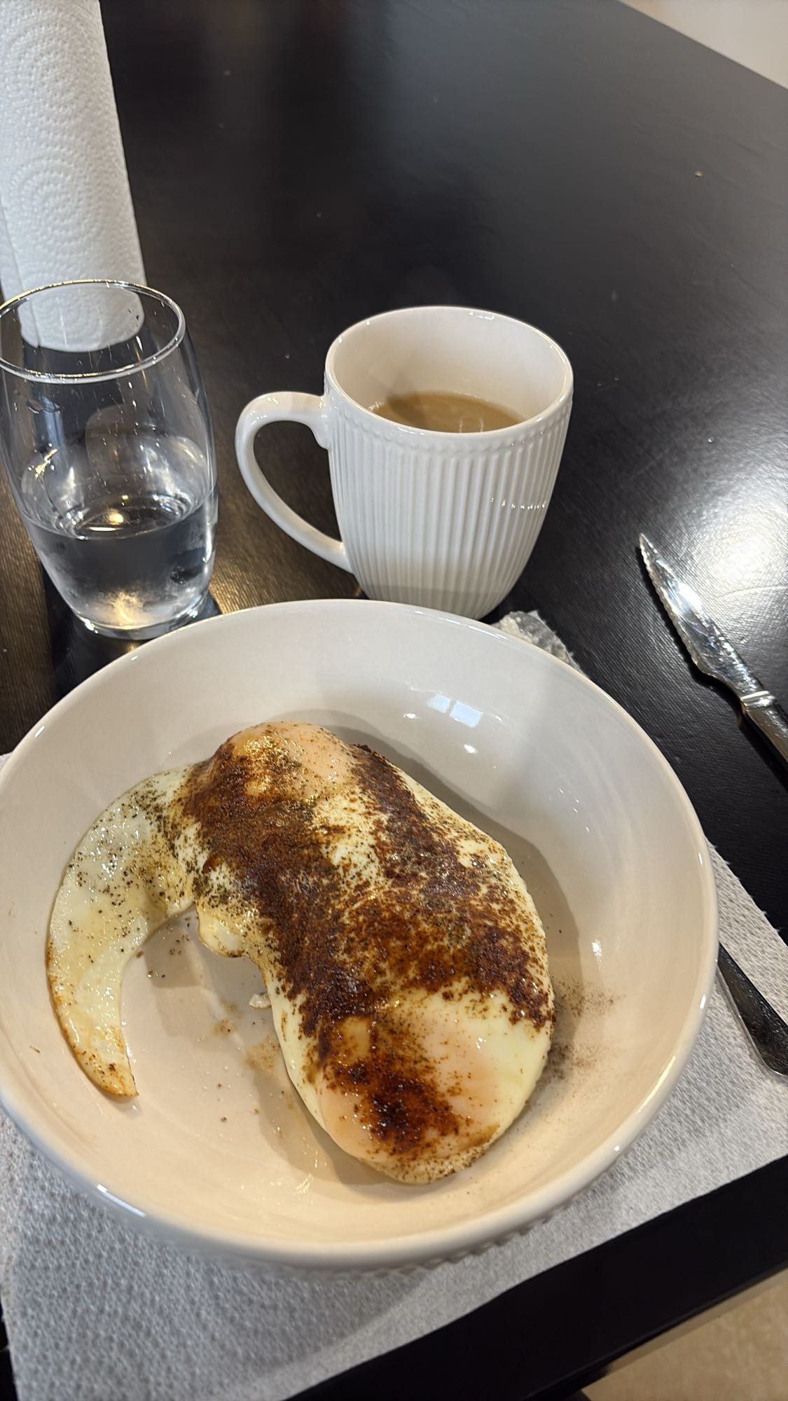 Deux œufs au plat, café, pain complet et cottage cheese