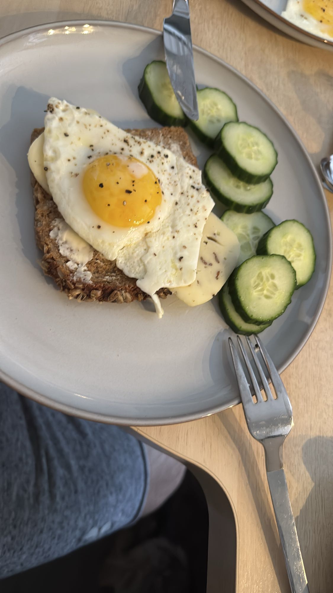 Vollkornbrot mit Butter, Spiegelei, Käse, Pfeffer, Salz und Salzgurkenscheiben