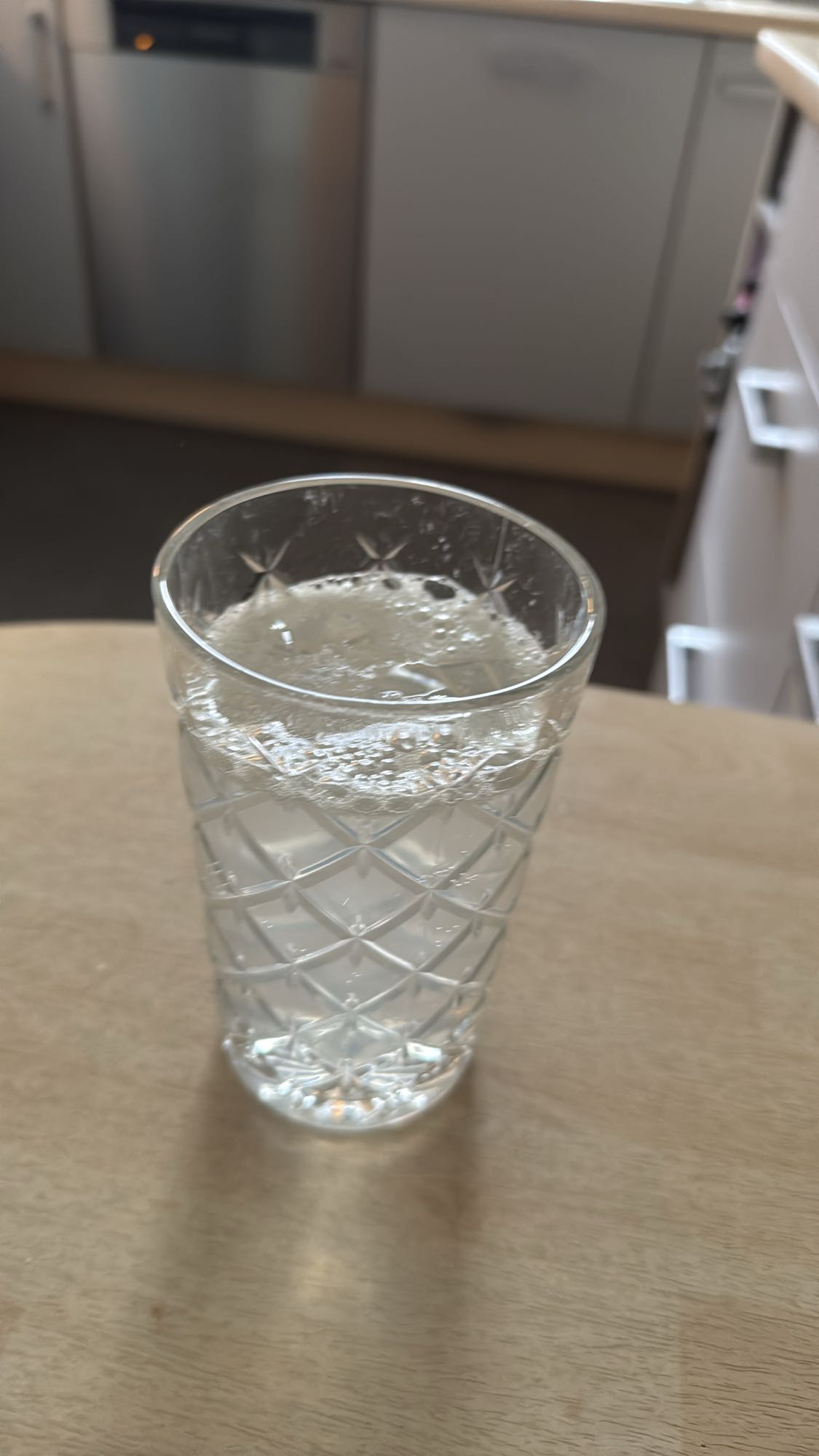 Glas Wasser mit ausgepresster Zitrone