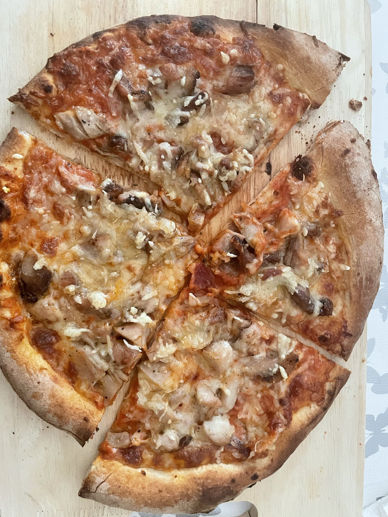 Pizza mit Hähnchenkeule und Champignons