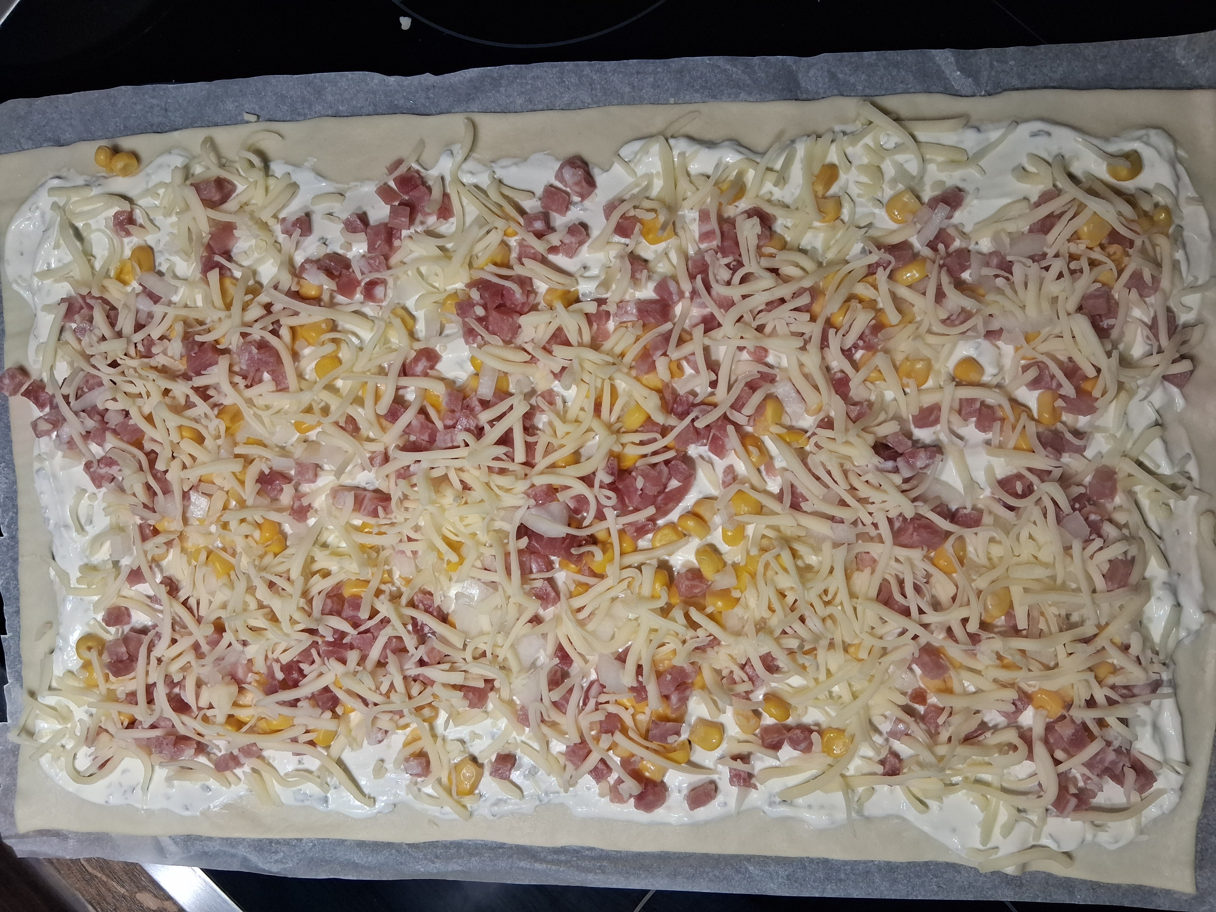 Schmand-Pizza mit Mais und Schinken