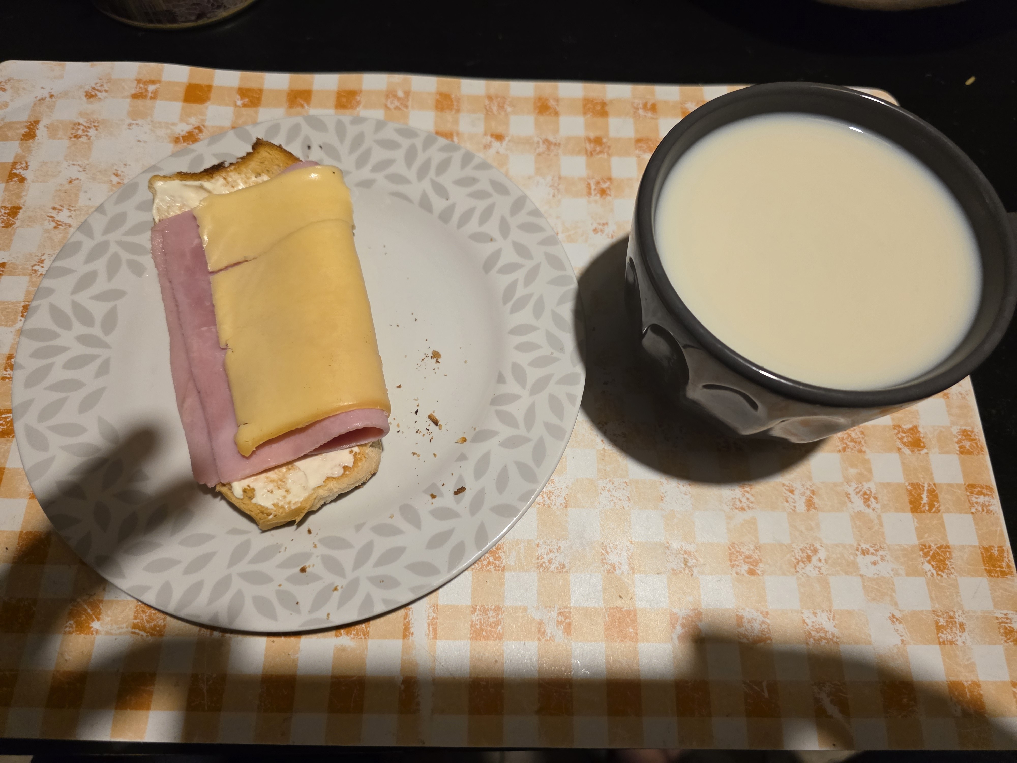 Mate cocido con leche parcialmente descremada y tostada con queso y jamón