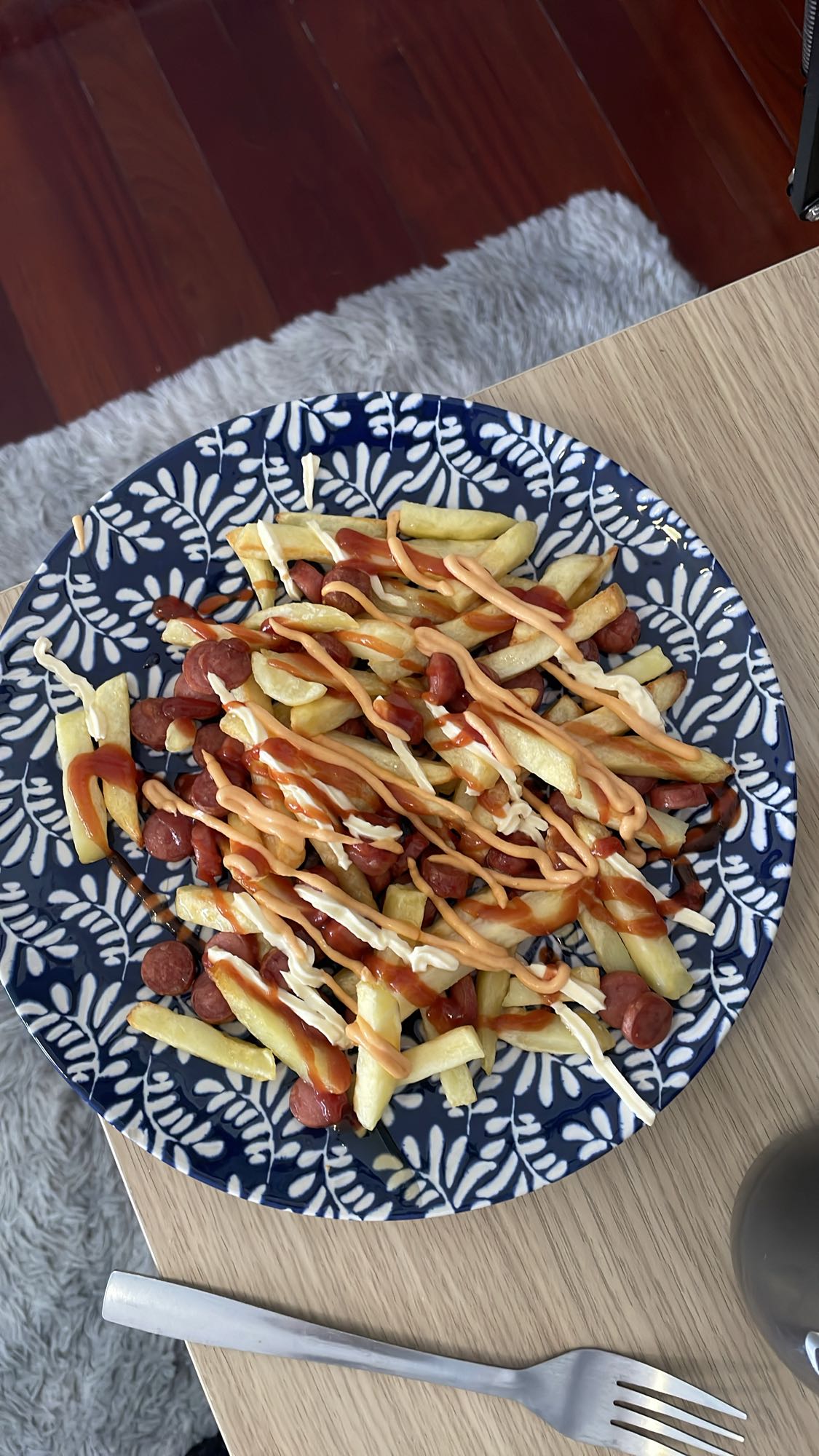 Papas fritas con salchicha y salsas