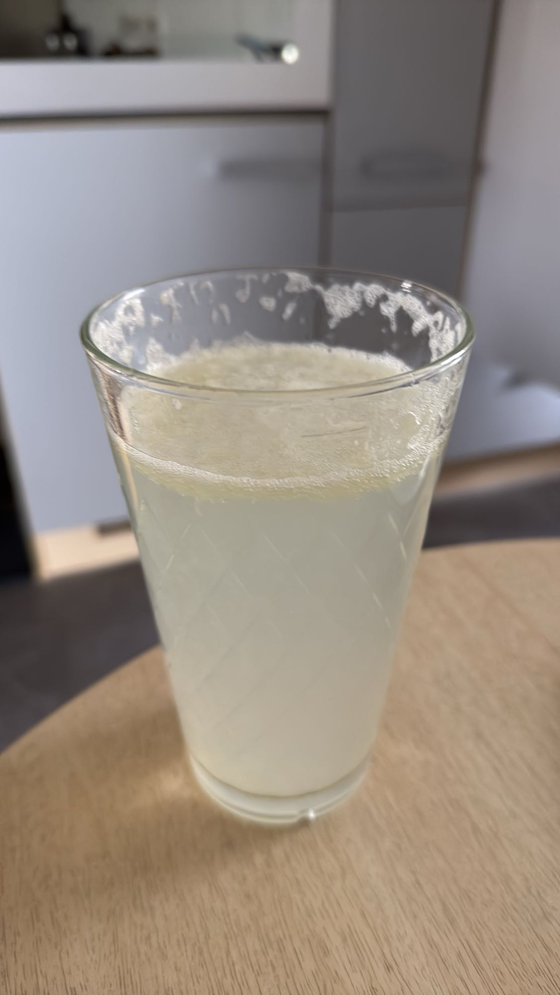 Ein Glas Wasser mit einer ausgepressten Zitrone