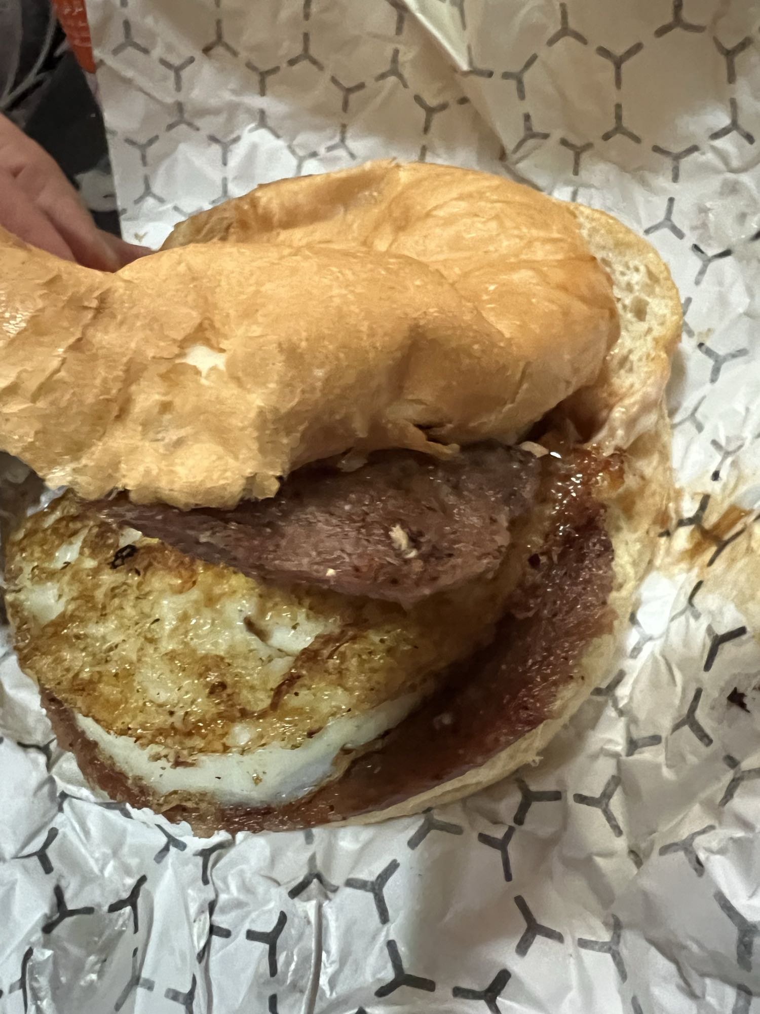 Double beef patty breakfast sandwich with egg and sauces