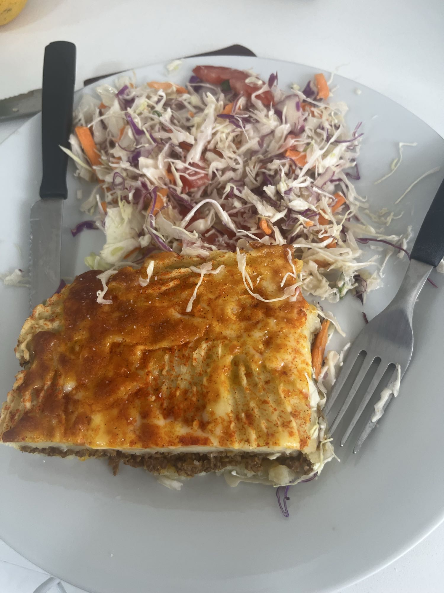 pastelón de papa relleno de carne con ensalada de repollos mixtos