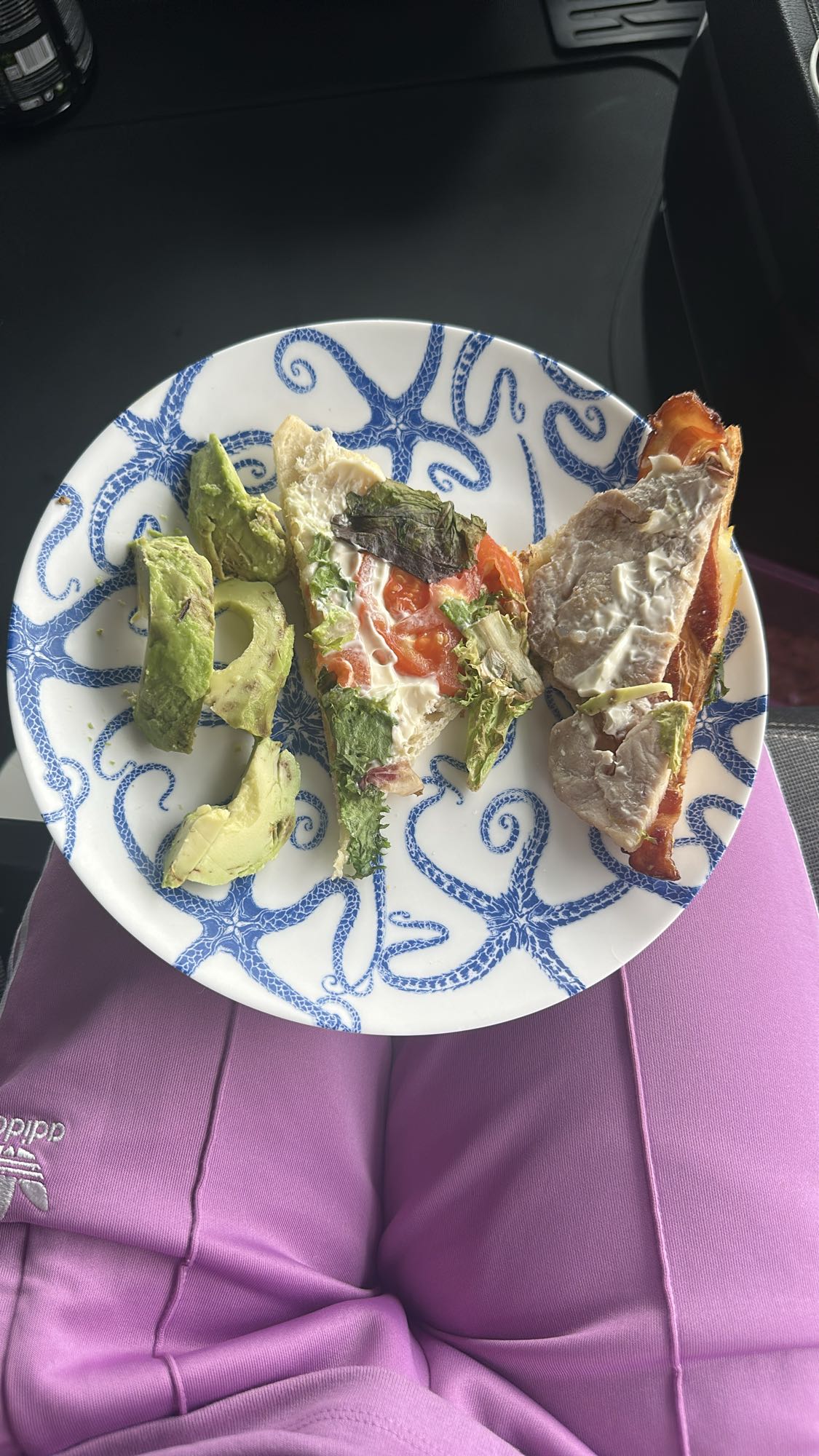 Jumătate de sandviș cu avocado, legume, pui și bacon și jumătate de avocado
