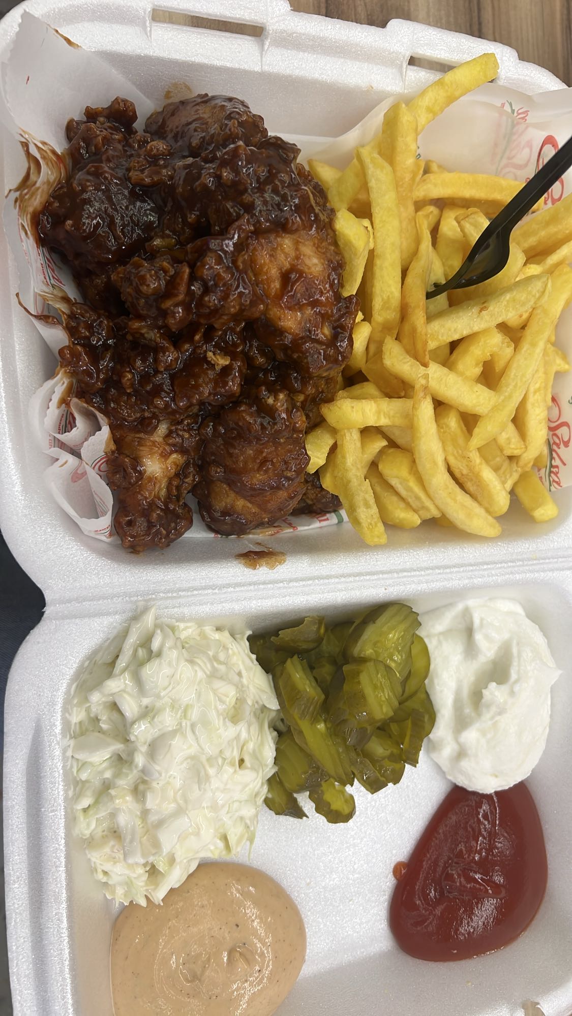 4 complete wings with barbecue sauce, 10 French fries strips, 3 small spoons coleslaw salad and 3 tranches of pickles