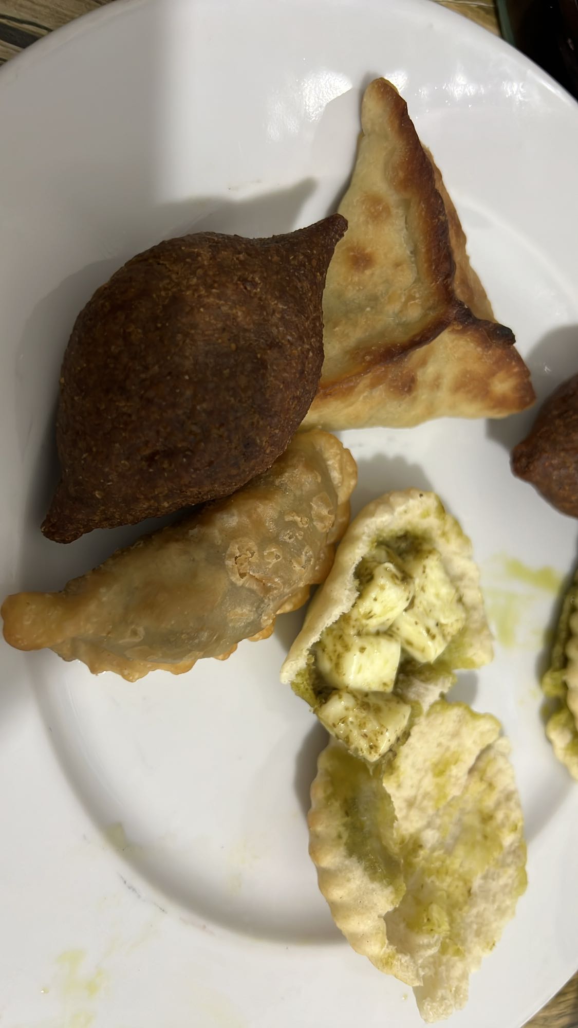 3 Kebbeh, 1 herbs fatayer, 3 meat smabusa and 3 feta cheese and pesto in small Arabic flatbread