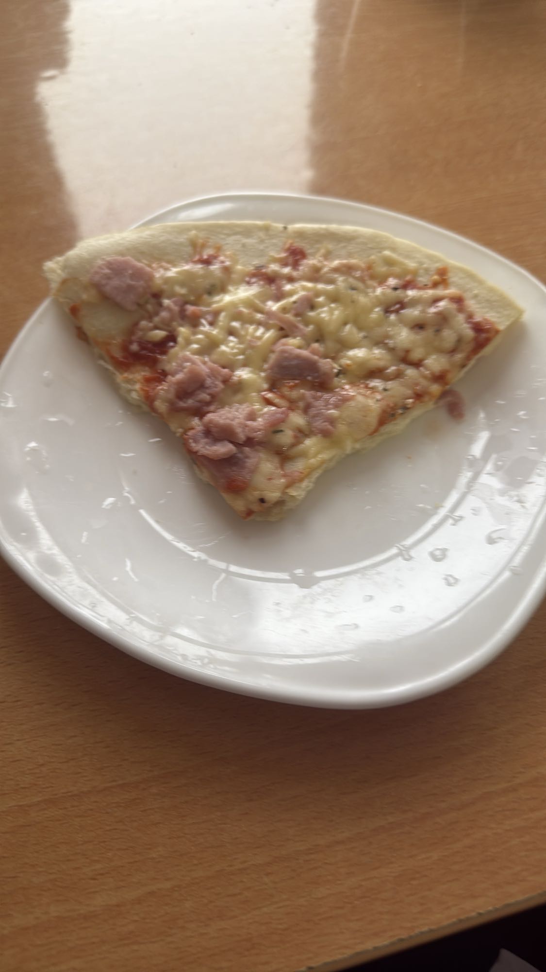 Кусок пиццы с ветчиной