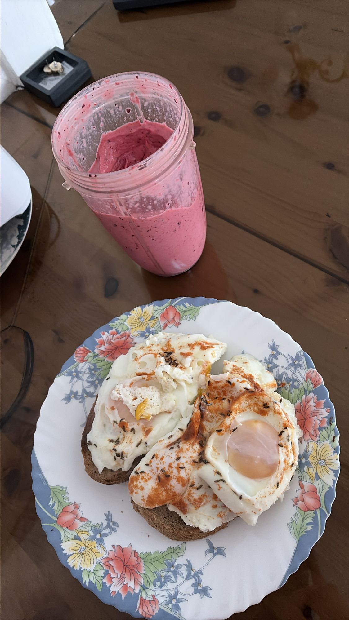 Pâine neagră cu ouă fierte în apă și smoothie cu fructe