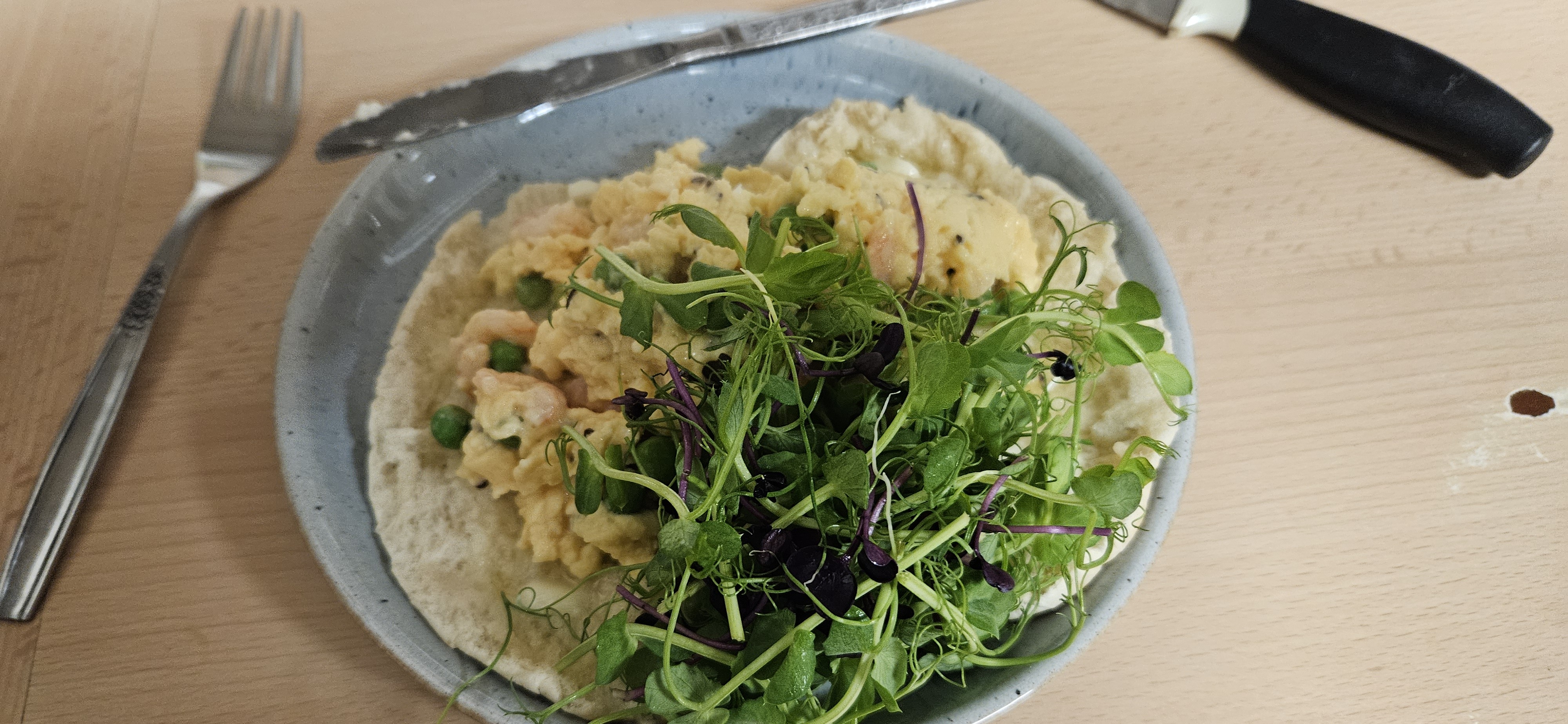 Scrambled egg wrap with greens and prawns