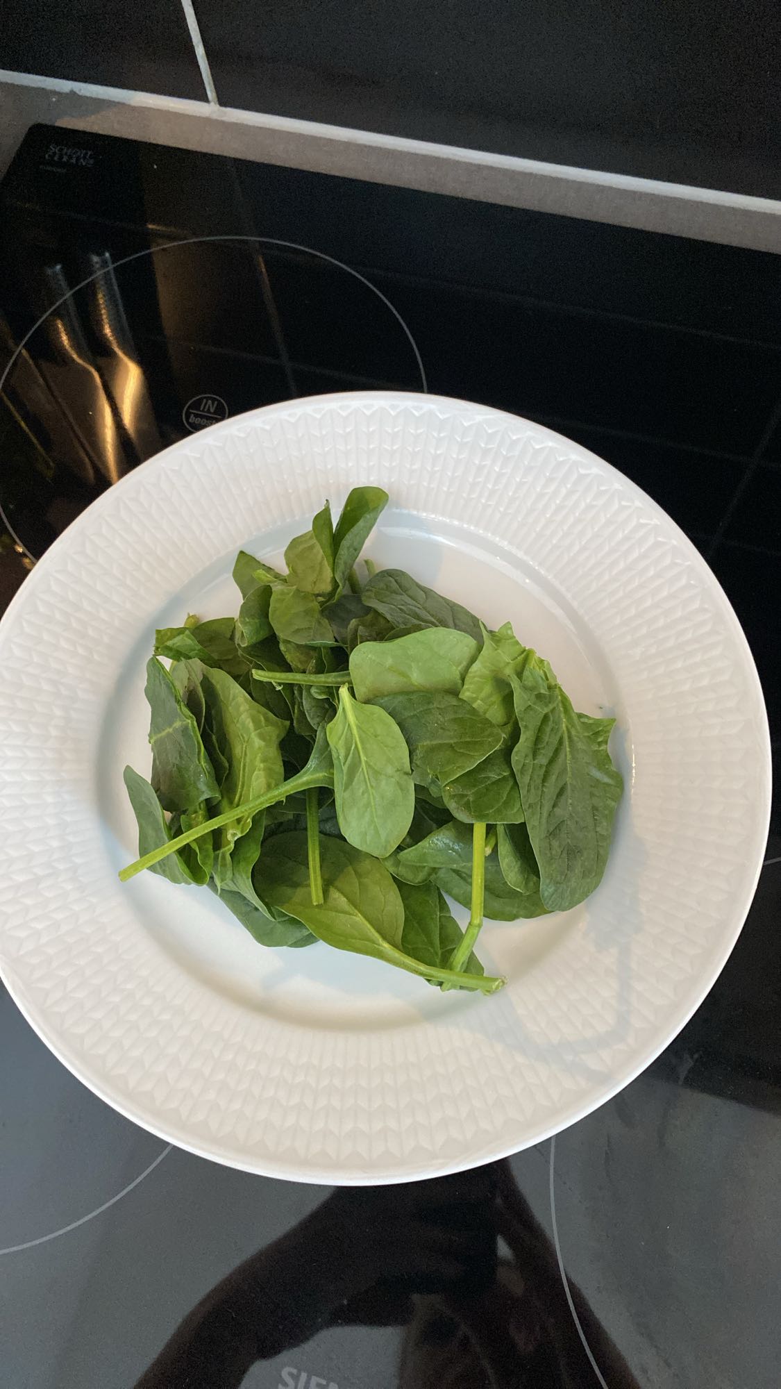 Färsk spenat på tallrik