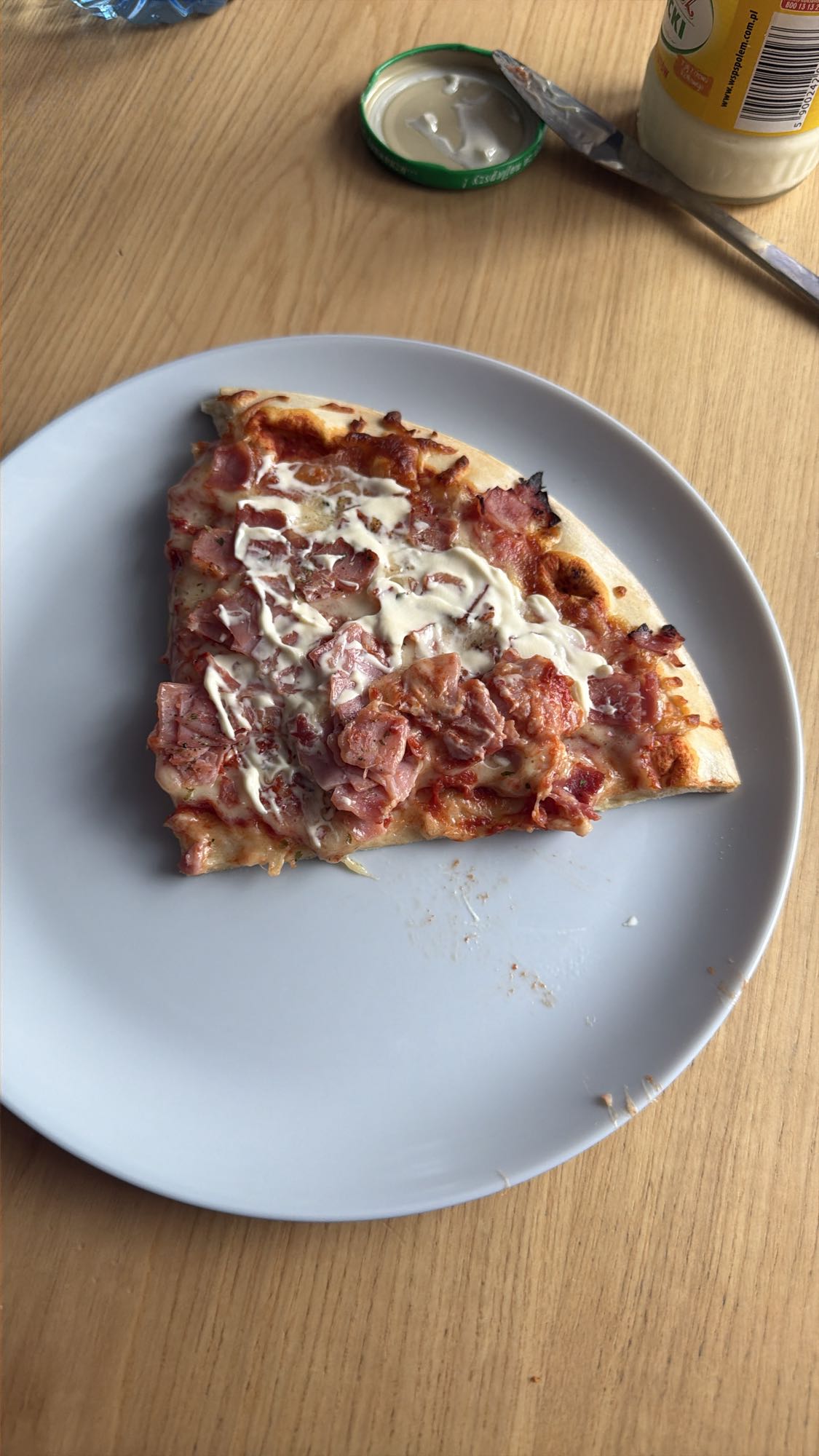Kawałek pizzy z szynką i majonezem